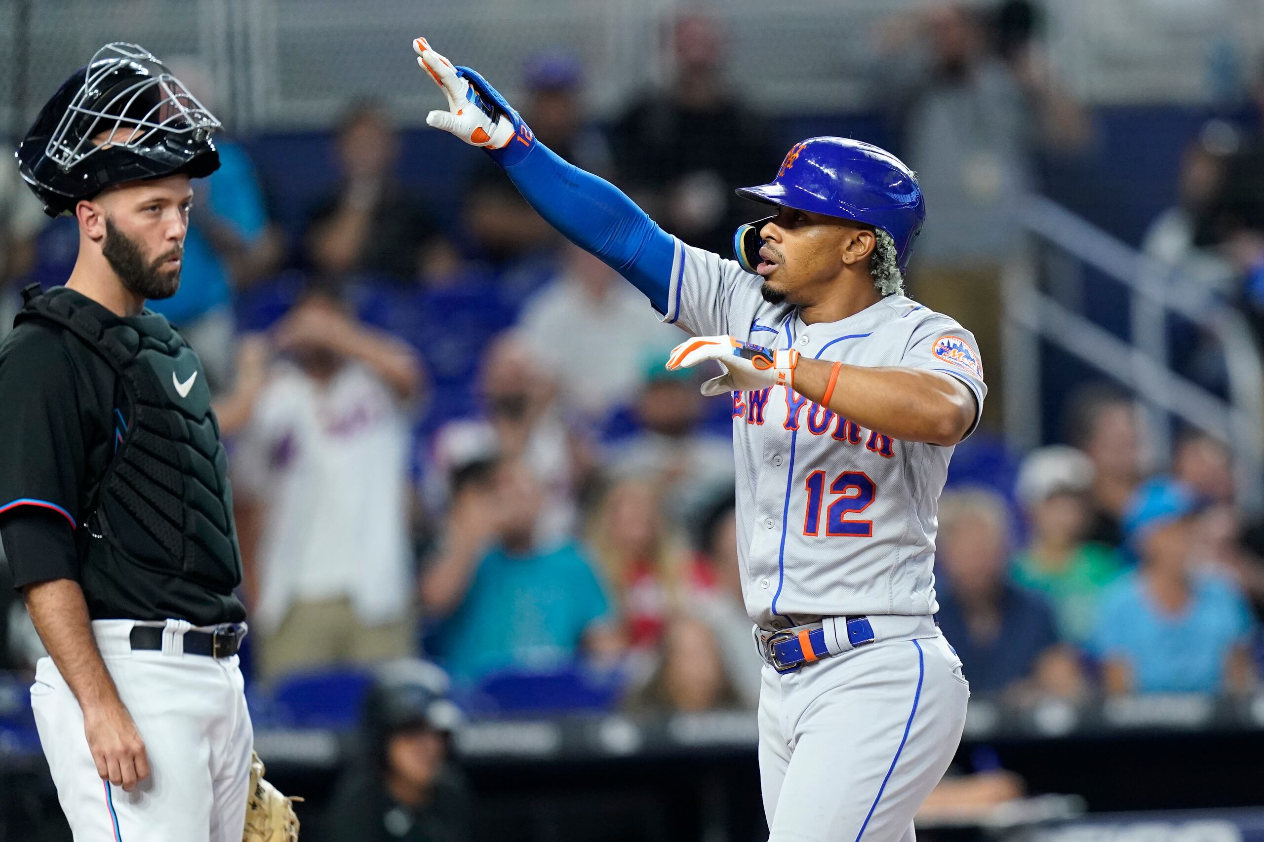 El boricua Francisco Lindor, de los Mets de Nueva York, anota tras conectar un jonrón solitario mientras le observa el catcher Jacob Stallings, de los Marlins de Miami.