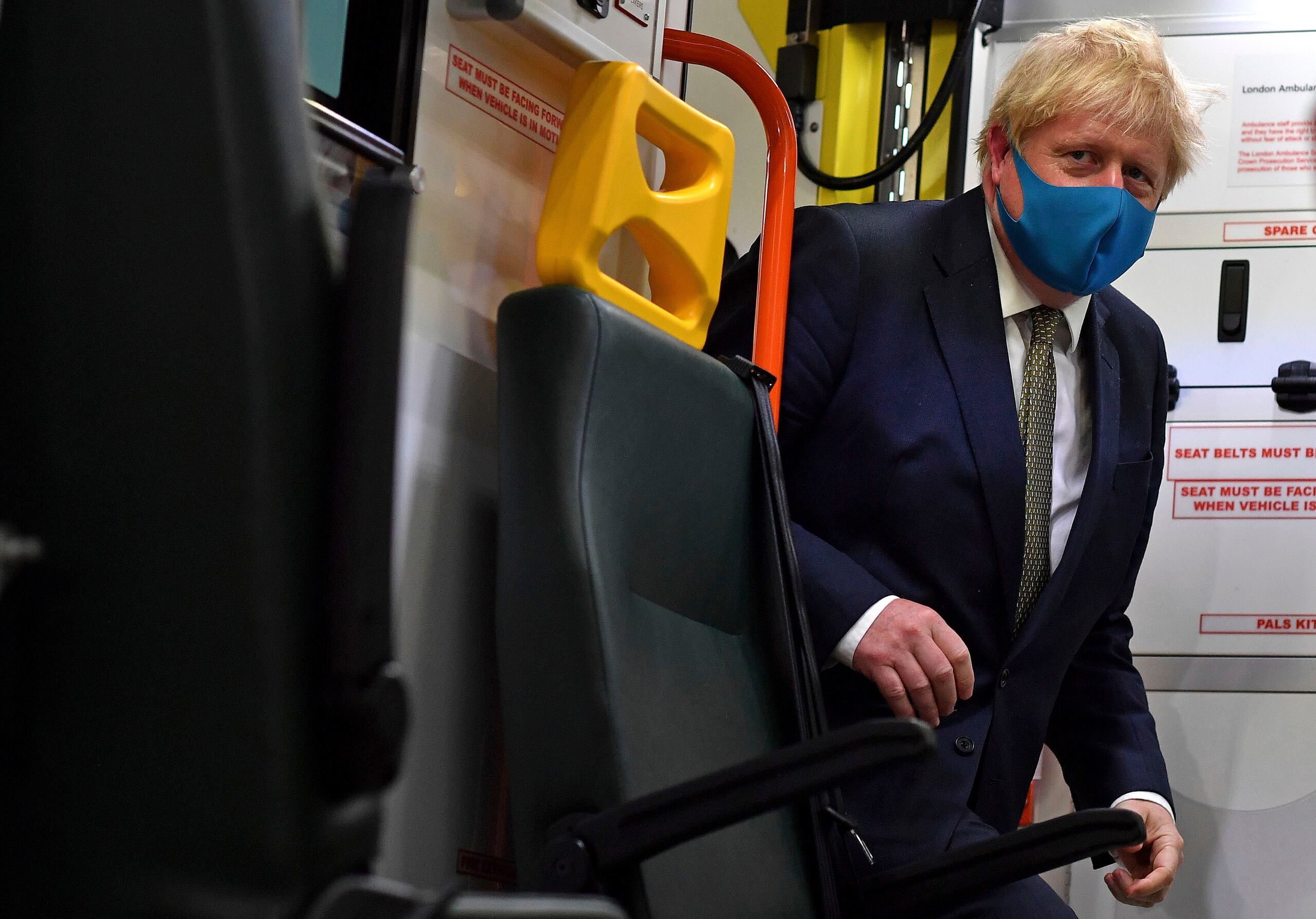 El primer ministro de Gran Bretaña, Boris Johnson, sube a una ambulancia con una mascarilla puesta durante una visita a la sede del Servicio de Ambulancia de Londres NHS Trust en Londres.