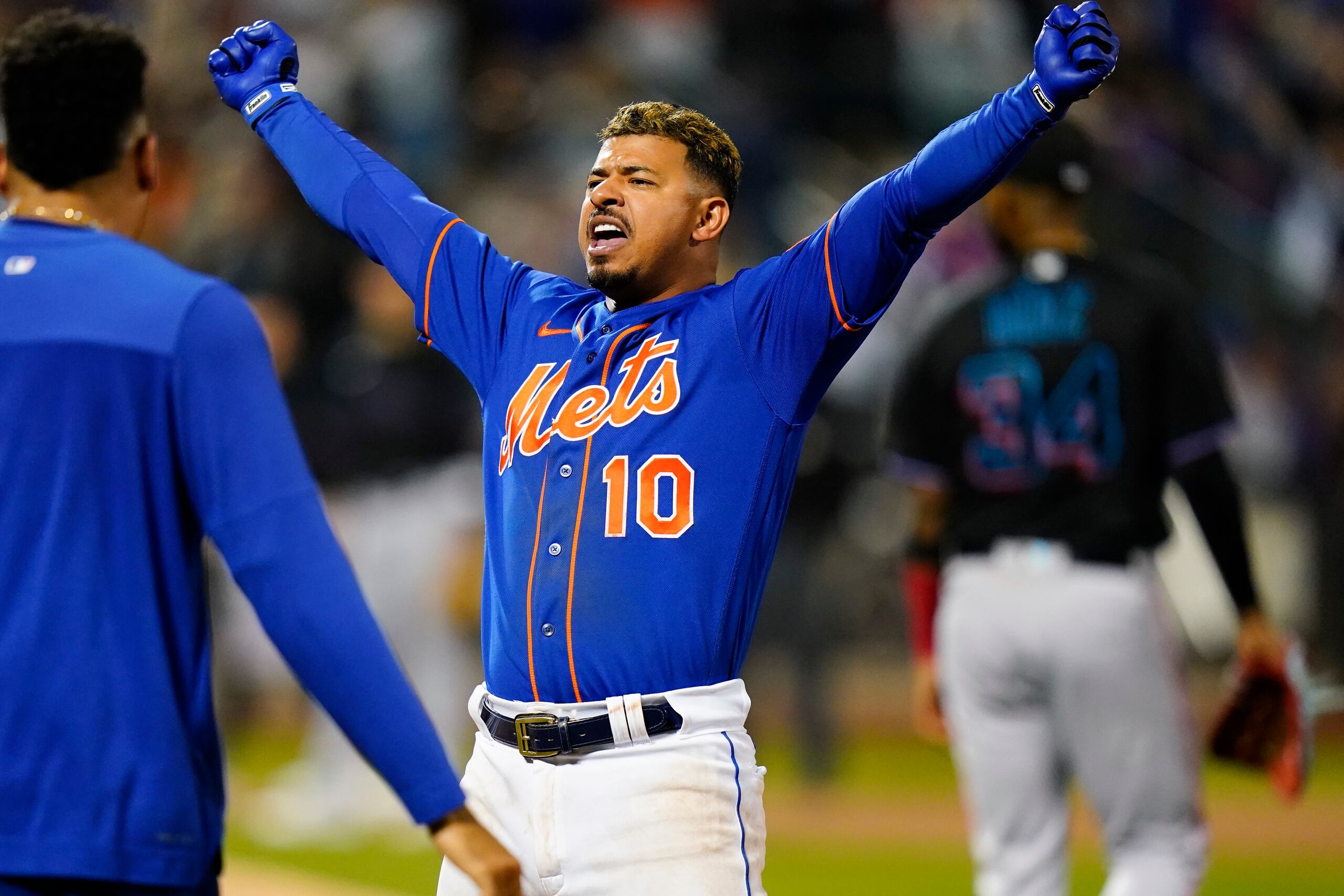 Eduardo Escobar, de los Mets de Nueva York, celebra tras pegar el batazo que dejó a los Marlins de Miami sobre el terreno durante la décima entrada del partido del miércoles.