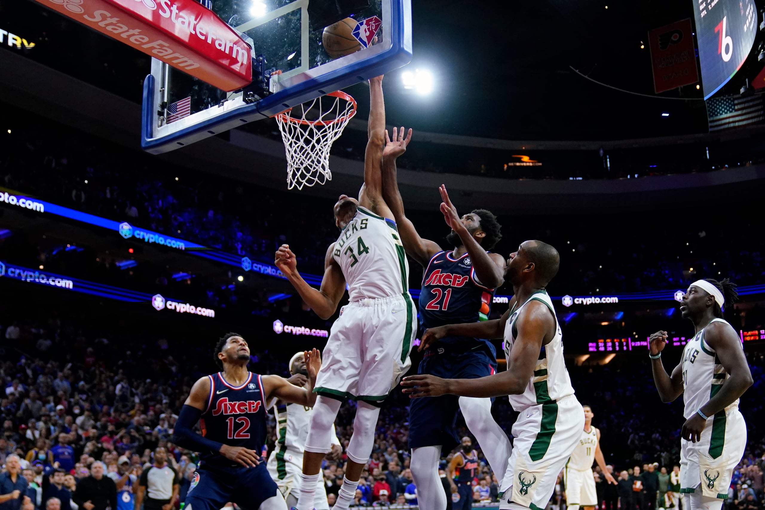 Giannis Antetokounmpo (34), de los Bucks de Milwaukee, le bloquea un disparo a Joel Embiid (21), de Filadelfia, en los segundos finales del encuentro del martes.