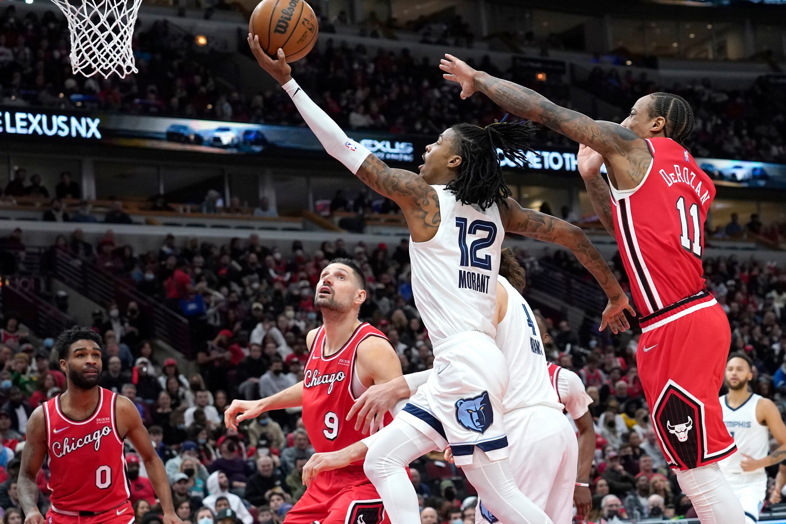 Ja Morant (12), de los Grizzlies de Memphis, deja atrás a DeMar DeRozan, de los Bulls de Chicago, en ruta al canasto.