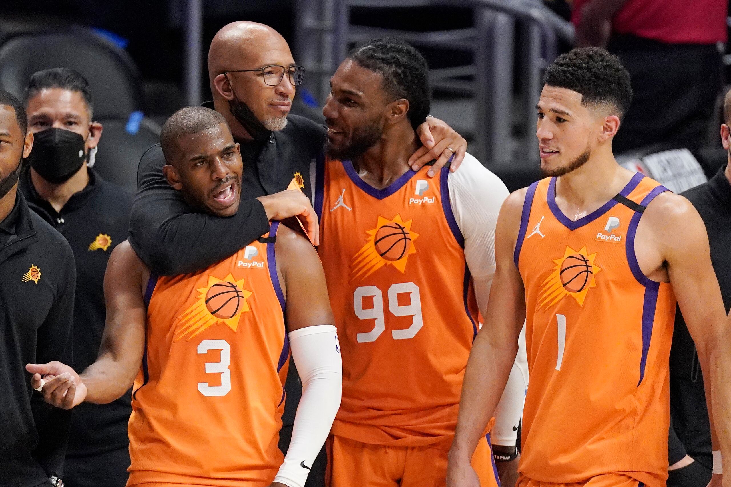 El dirigente de los Suns de Phoenix, Monty Williams, abraza a Chris Paul (3), Jae Crowder (99) y Devin Booker durante los segundos finales del partido del miércoles en Los Ángeles. Los Suns eliminaron a los Clippers y pasaron a la Final de la NBA.