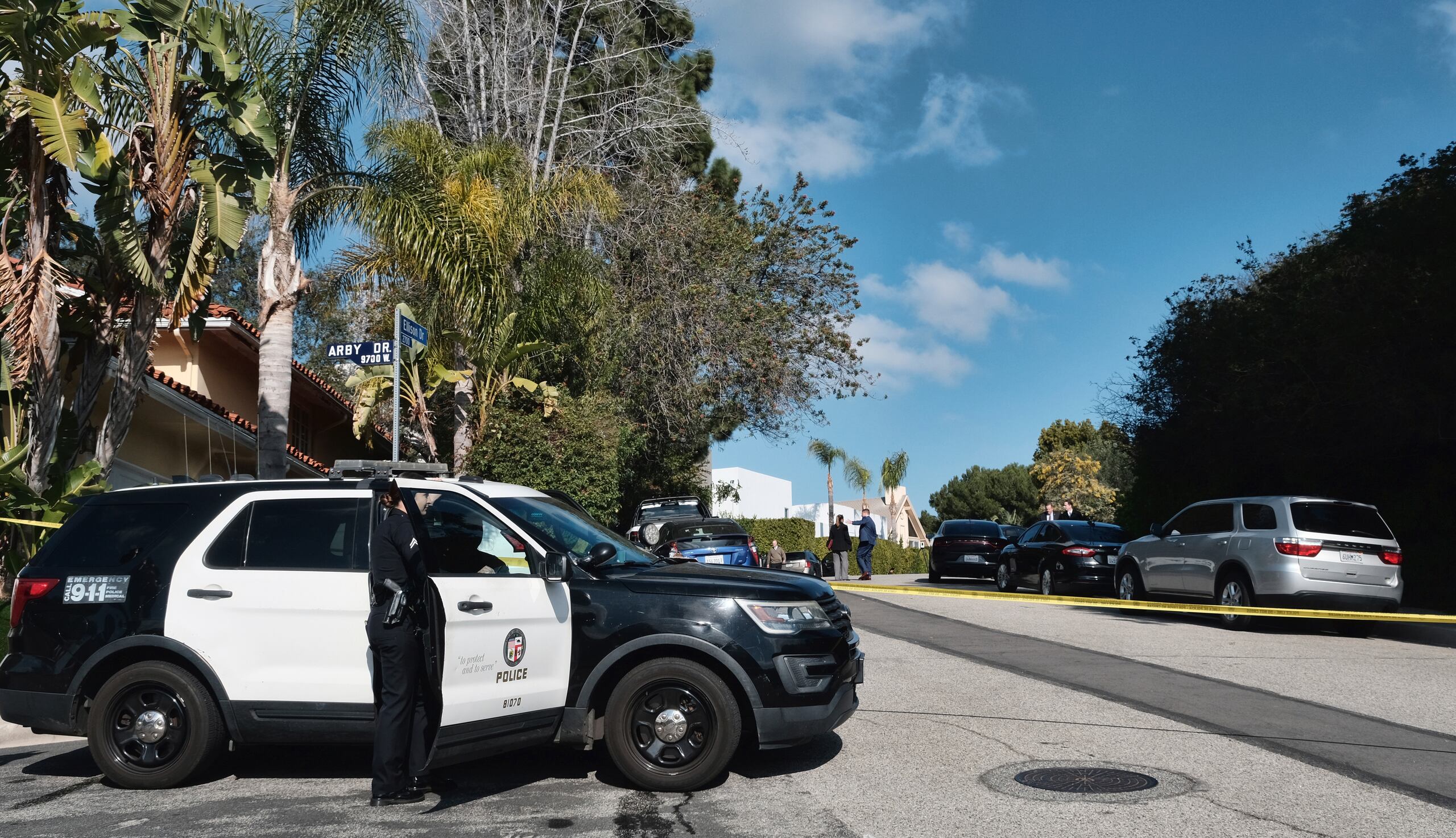 La policía acordona la calle en donde tres personas murieron y cuatro más resultaron heridas en un tiroteo en una casa en un exclusivo vecindario de Los Ángeles.