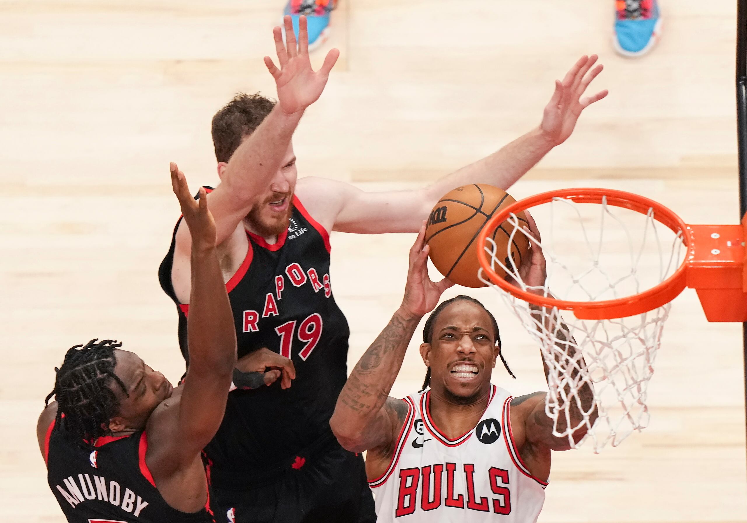 DeMar DeRozan, alero de los Bulls de Chicago, salta para encestar frente a O.G. Anunoby y Jakob Poeltl (19) de los Raptors de Toronto, durante el partido del miércoles.