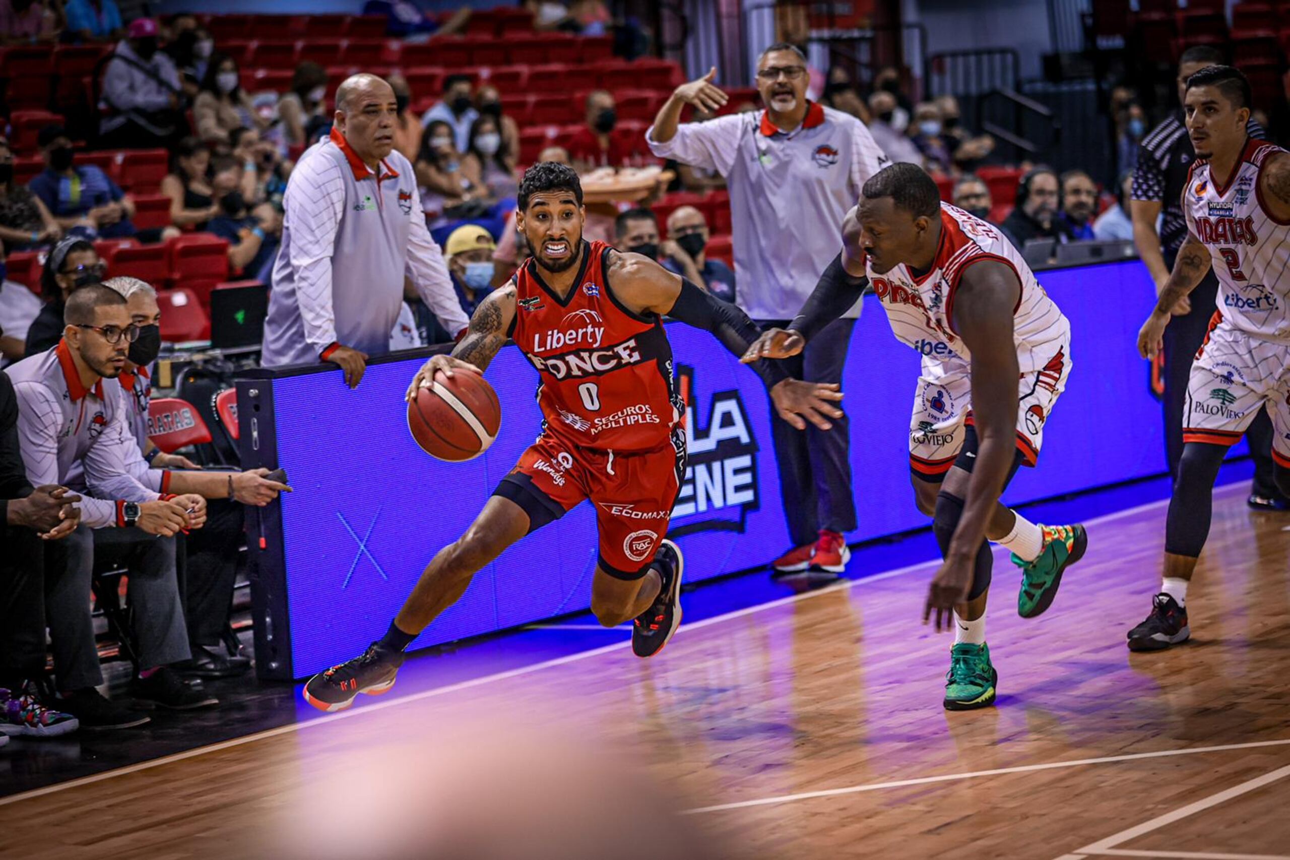 Jezreel de Jesús, de los Leones de Ponce, con el balón, aprovecha el pareo con Ramón Clemente, de los Piratas, y aprieta el paso hacia el canasto el martes en la Raymond Dalmau.