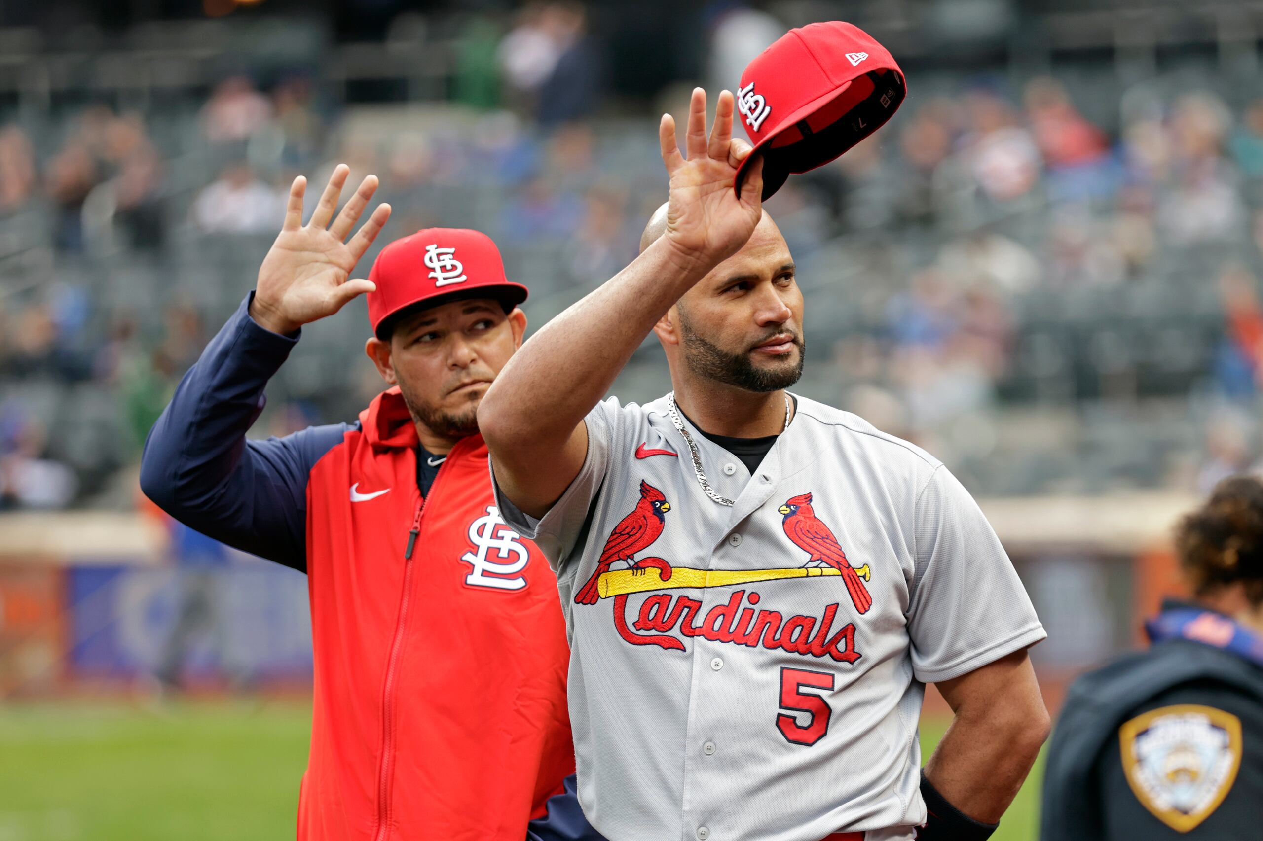 Yadier Molina y Albert Pujols saludan al público en medio del reconocimiento que le hicieran los Mets antes de iniciar el último partidos de temporada regular de estos en el estadio de Nueva York.