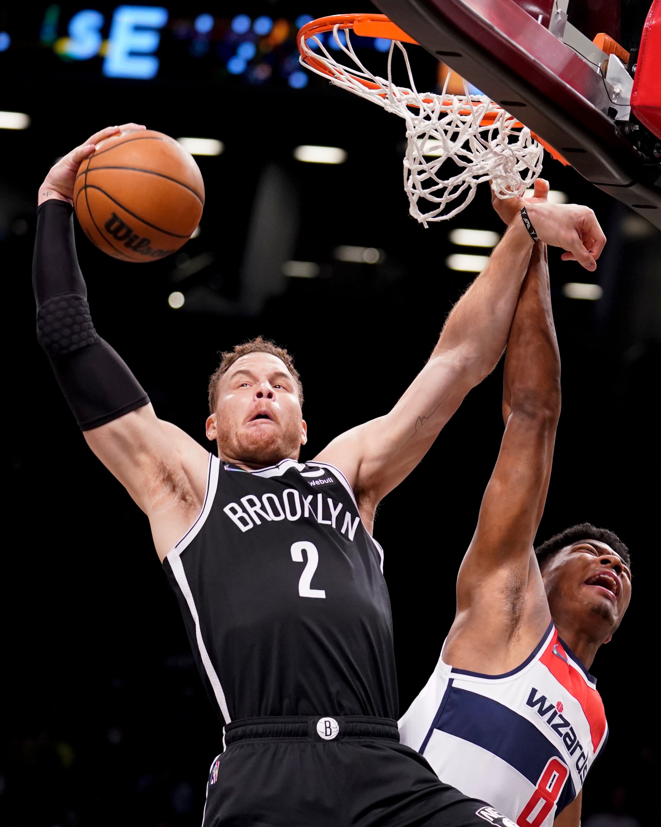 En foto del 17 de febrero del 2022, Blake Griffin de los Nets de Brooklyn toma un rebote superando al alero de los Wizards de Washington Rui Hachimura. (AP Foto/John Minchillo)