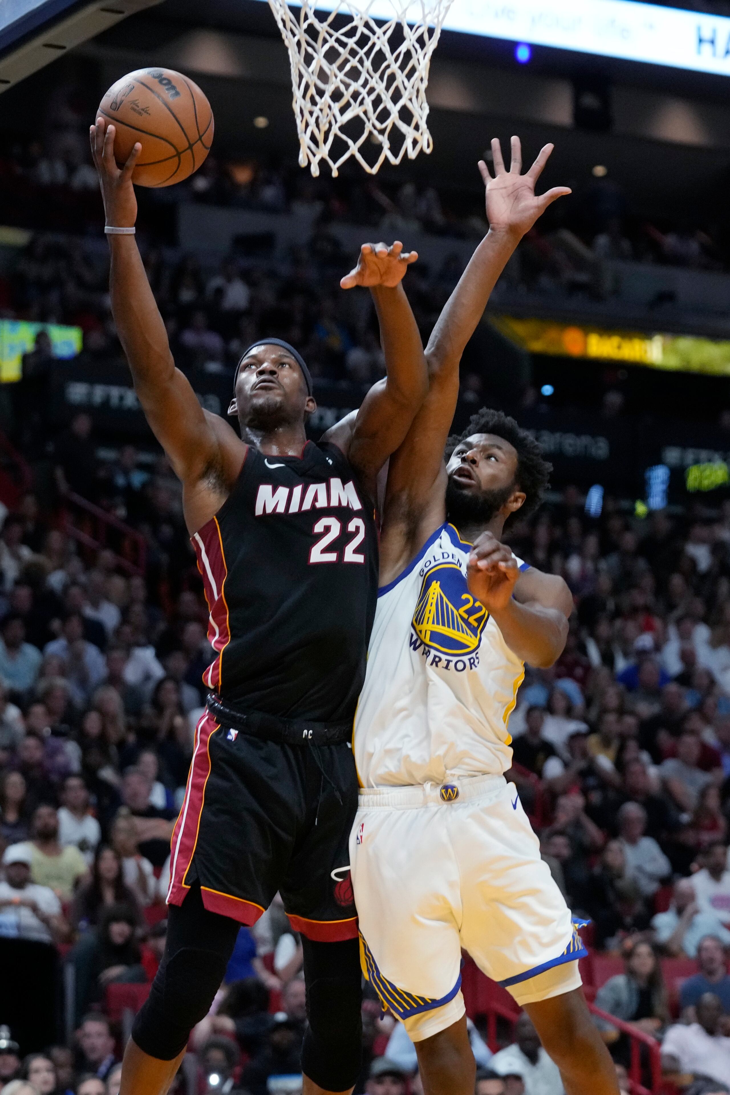 El delantero del Heat de Miami, Jimmy Butler, se levanta para colar un canasto ante la defensa de Andrew Wiggins, de los Warriors de Golden State.