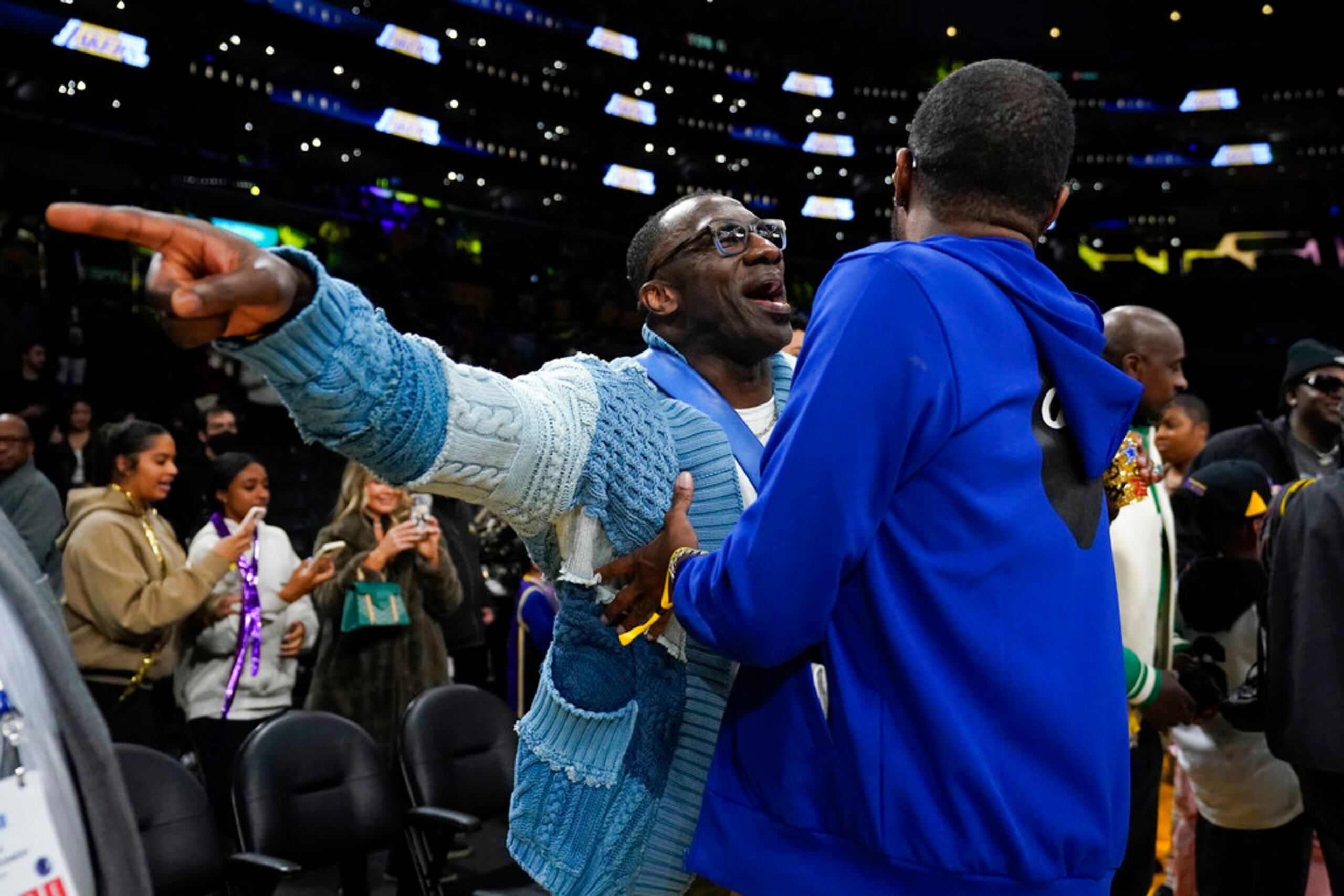 El exjugador de la NFL, Shannon Sharpe (izquierda), conversa con Tee Morant,  padre de Ja Morant, durante el encuentro entre los Lakers y los Grizzlies.