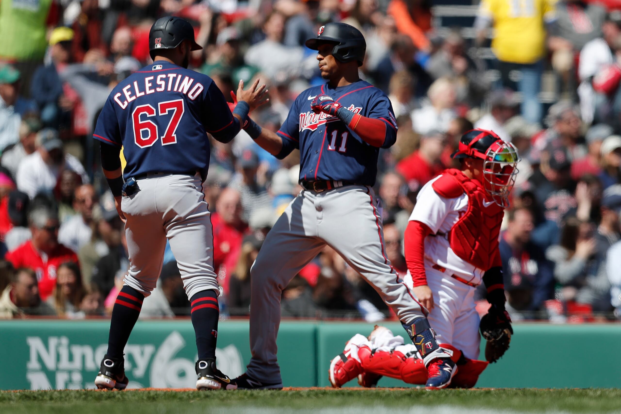 Jorge Polanco (11) festeja con Gilberto Celestino el jonrón que conectó en la victoria 8-3 de los Mellizos sobre los Medias Rojas en Boston el 18 de abril del 2022. (AP Photo/Michael Dwyer)