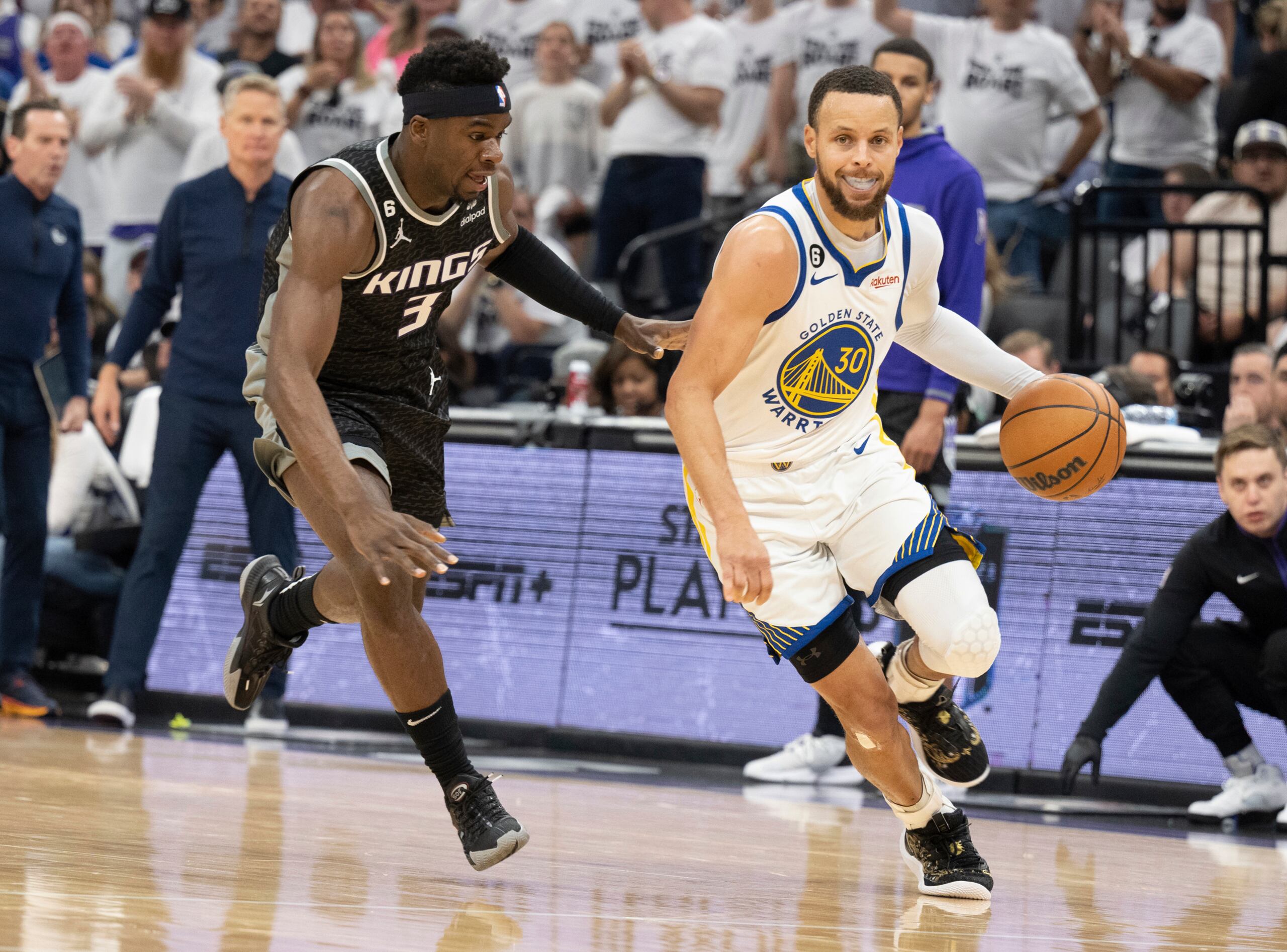 Stephen Curry, de los Warriors de Golden State, frente a Terence Davis, de los Kings de Sacramento, en una penetración durante el partido decisivo del domingo.