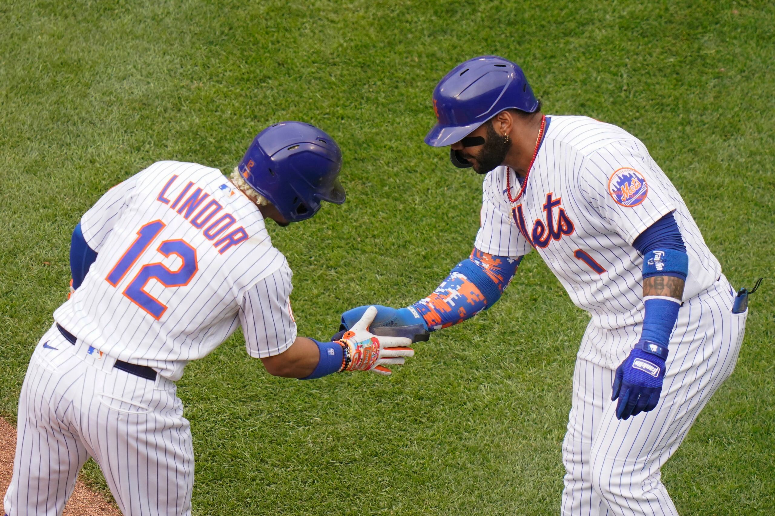 Francisco Lindor y Johnathan Villar, de los Mets de Nueva York, celebran el vuelacercas de Lindor que los hizo anotar a ambos el sábado ante los Padres de San Diego.