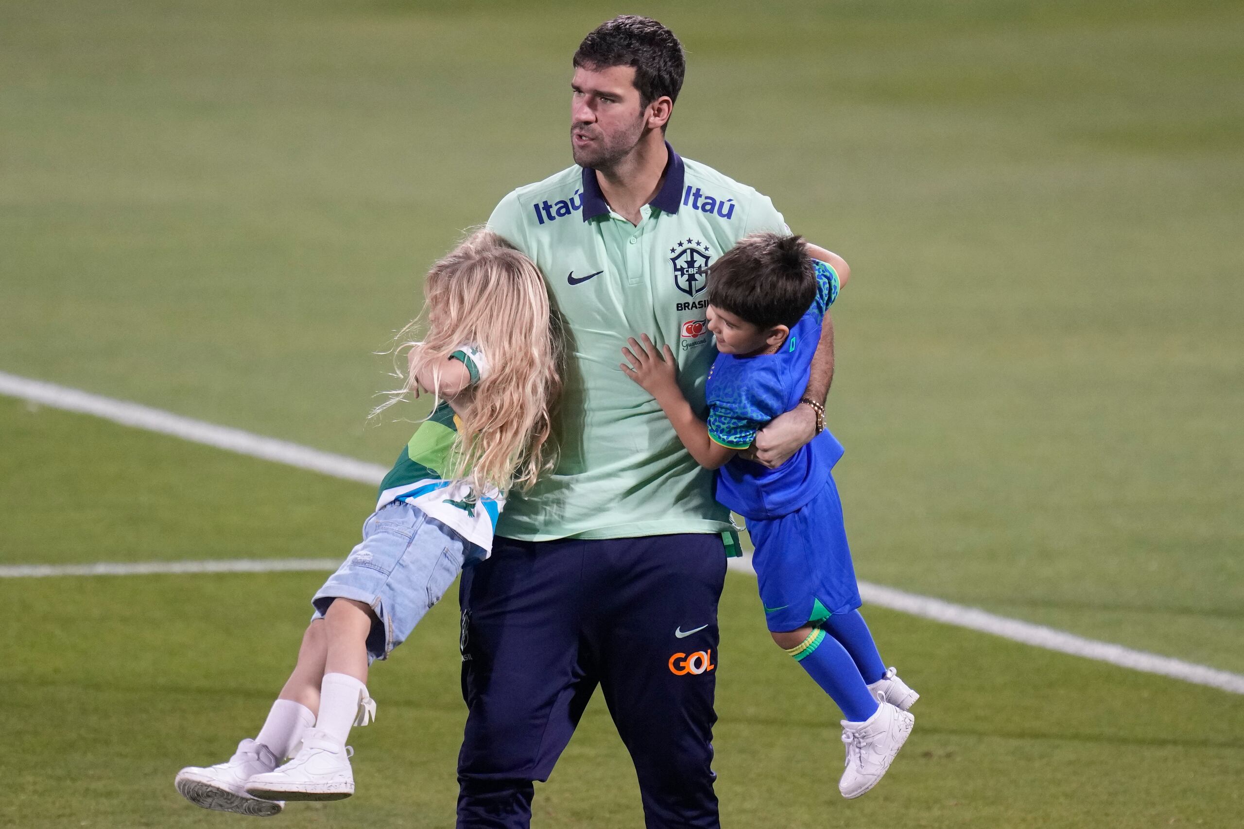 El arquero brasileño Alisson juega con su hija Helena y su hijo Matteo tras un entrenamiento. Brasil enfrentará a Camerún el viernes en el Mundial. (AP Foto/Andre Penner)