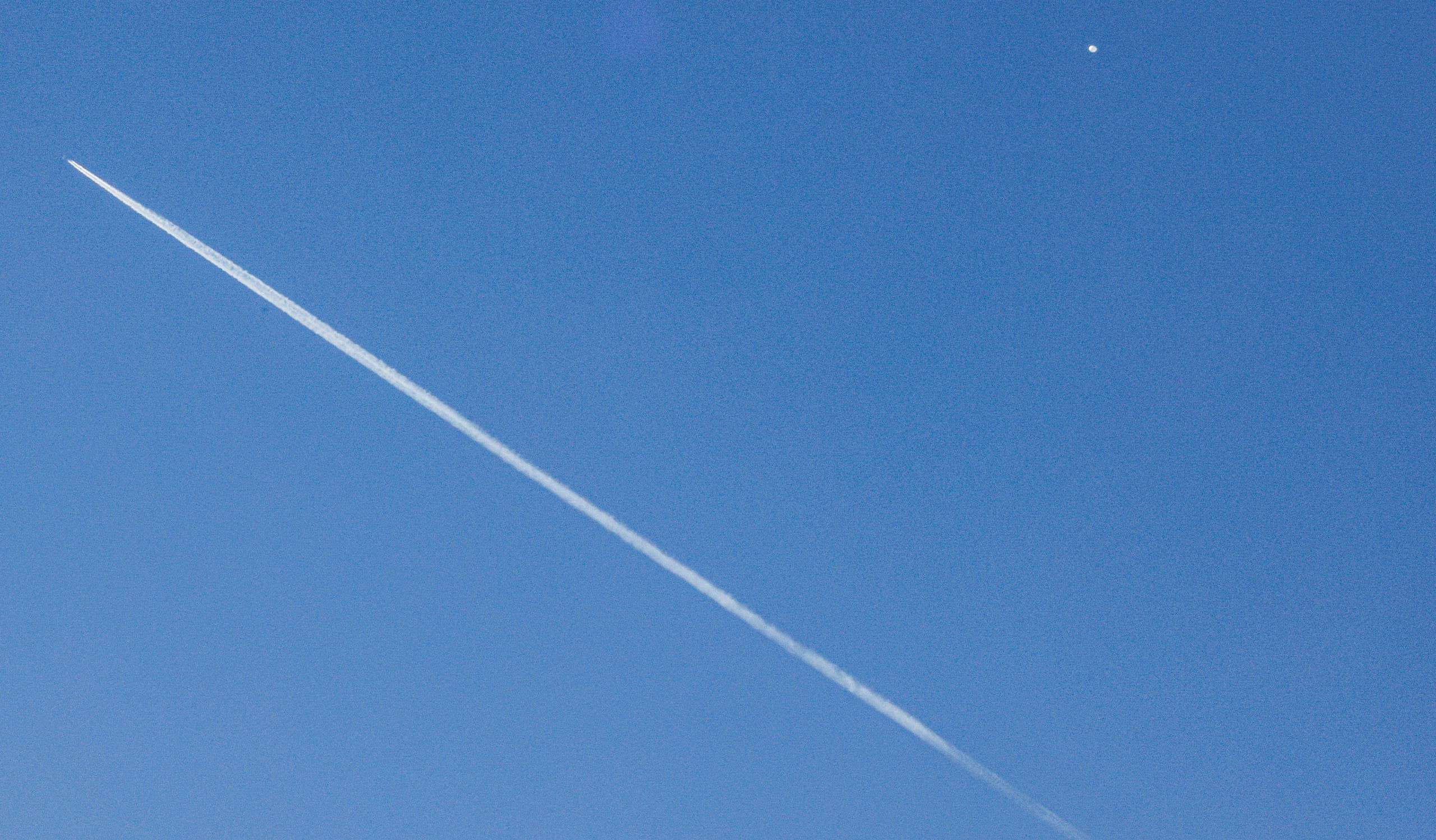 Un avión comercial (i) vuela por debajo del "globo espía" chino (d) detectado en el espacio aéreo estadounidense, este sábado en Charlotte, en Carolina del Norte.