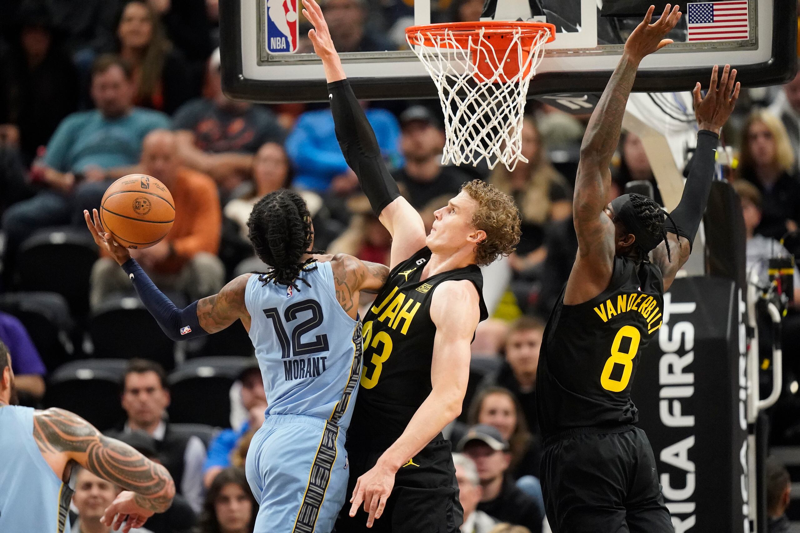 El base de los Grizzlies de Memphis Ja Morant ataca el canasto ante el alero del Jazz de Utah Lauri Markkanen en la primera mitad del partido del lunes 31 de octubre de 2022, en Salt Lake City. (AP Foto/Rick Bowmer)