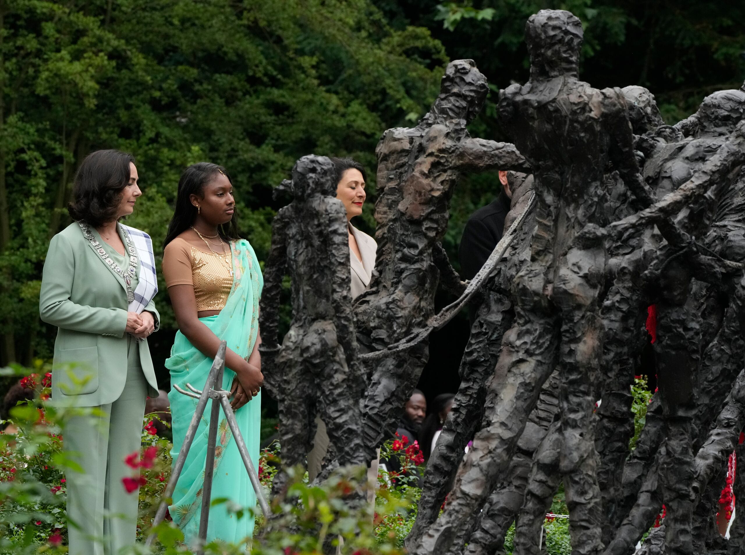 La alcaldesa de Ámterdam, Femke Halsema, izquierda, deposita una corona de flores en el Monumento Nacional de la Esclavitud después de ofrecer disculpas por la participación de los dirigentes de la ciudad en el comercio de esclavos, en una ceremonia anual transmitida por televisión a nivel nacional, en Ámsterdam, Holanda.