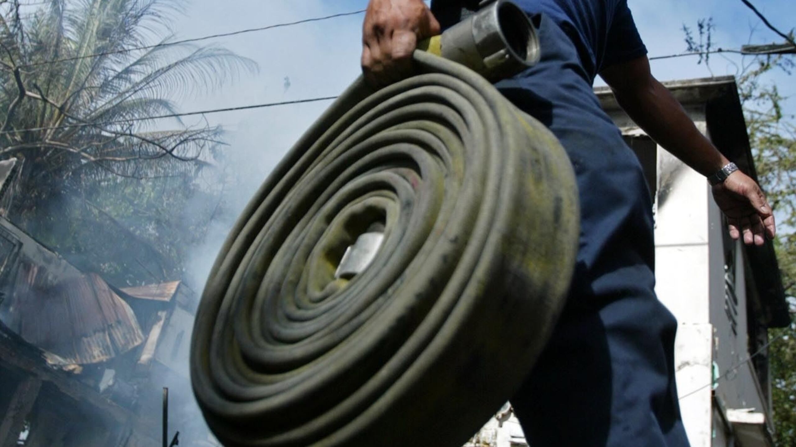 Un bombero carga una manguera para extinguir incendios. (GFR Media)