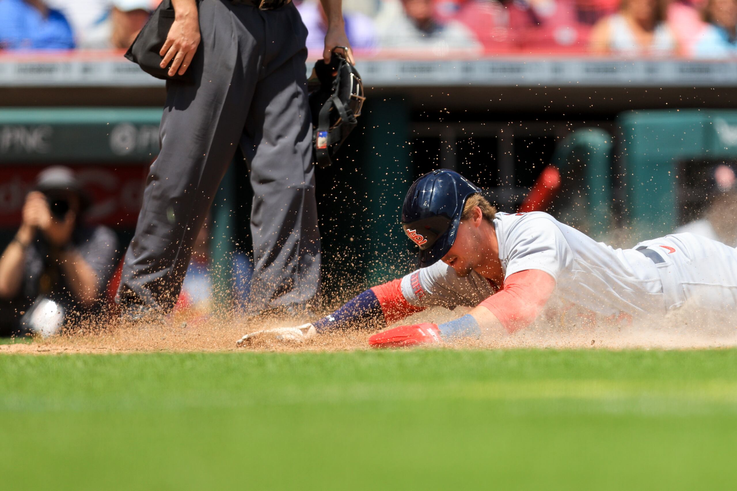 Nolan Gorman, de los Cardinals de San Luis, se desliza en el plato para anotar tras un lanzamiento descontrolado de Lucas Sims, de Cincinnati, el jueves.