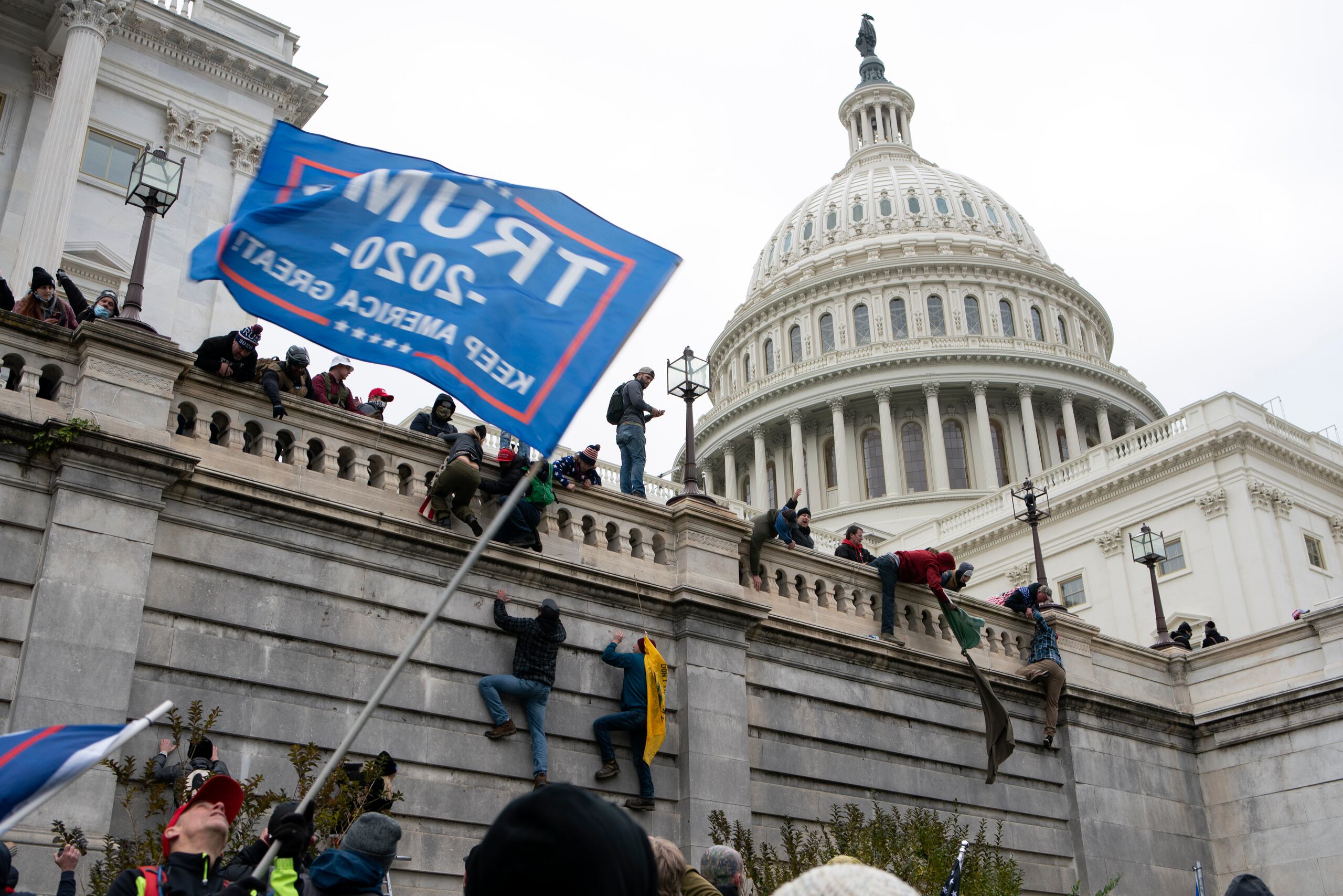 Esta foto del 6 de enero del 2021 muestra a violentos partidarios del presidente Donald Trump escalando el muro del Capitolio en Washington.