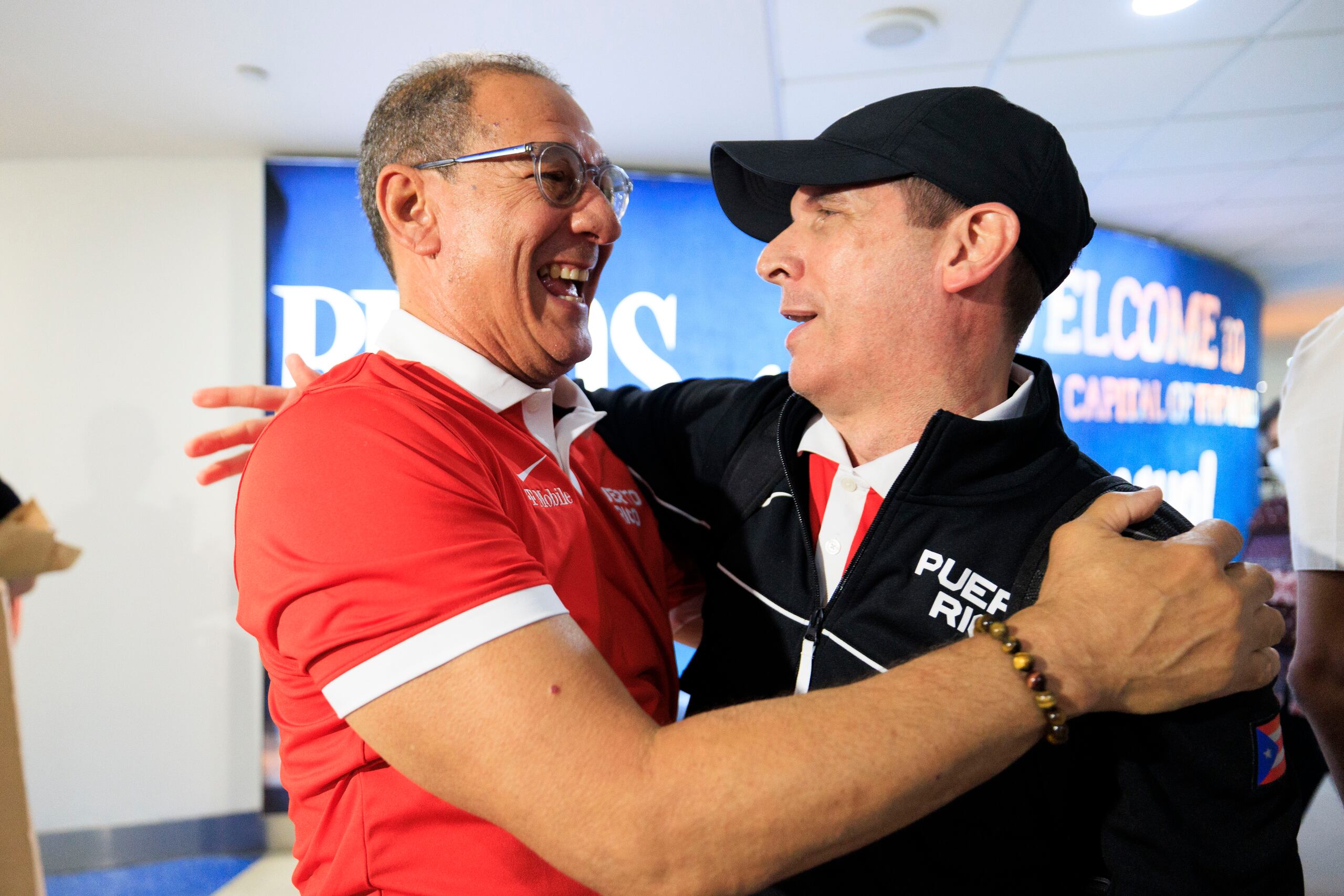 El reputado técnico Edmundo 'Mundi' Báez, secretario general de la Federación de Baloncesto, felicita a Jerry Batista en la llegada del Equipo Nacional de Baloncesto Femenino a la Isla luego del Centrobasket.