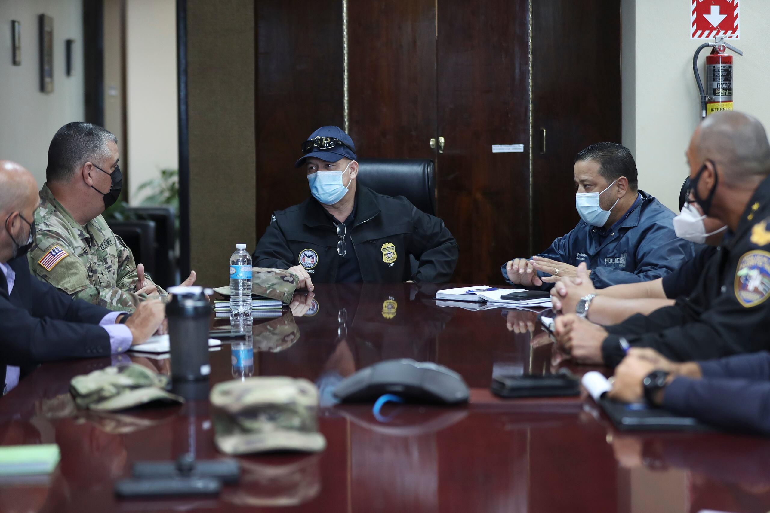 El comisionado de la Policía, Henry Escalera; el secretario de Seguridad Pública, Pedro Janer, y Miguel Méndez, general de brigada de la Guardia Nacional, discuten el plan de trabajo para hacer cumplir la orden ejecutiva del coronavirus.