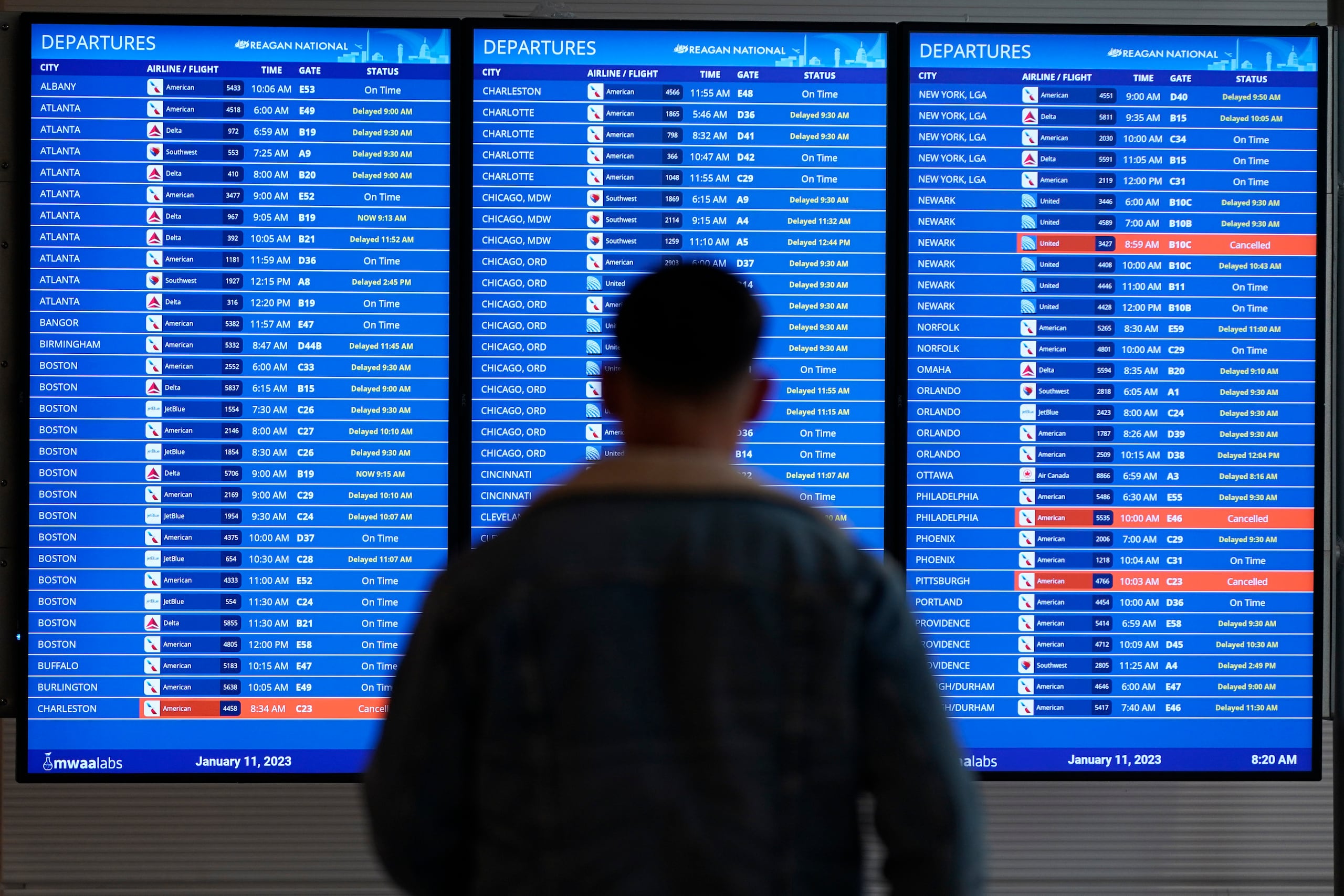 Un pasajero ve la pantalla del estatus de los vuelos en el aeropuerto Ronald Reagan, en Arlington.