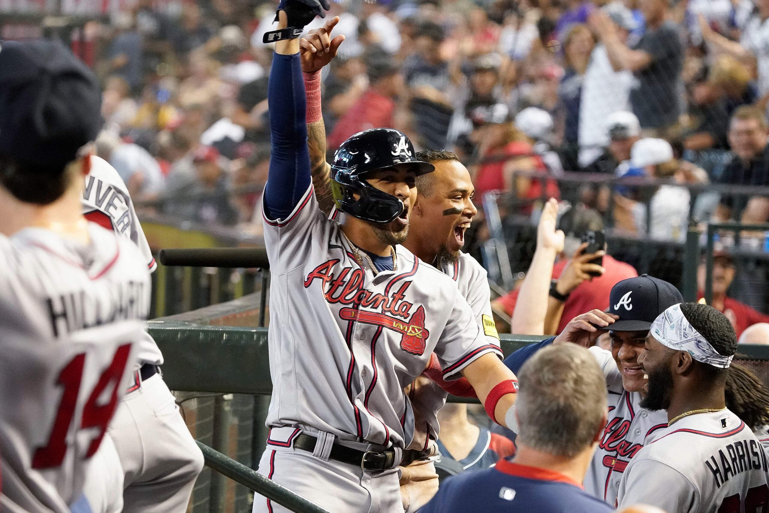 Eddie Rosario, centro, de los Braves de Atlanta, celebra después de batear un grand slam en contra de los Diamondbacks de Arizona durante la novena entrada del juego en Phoenix.