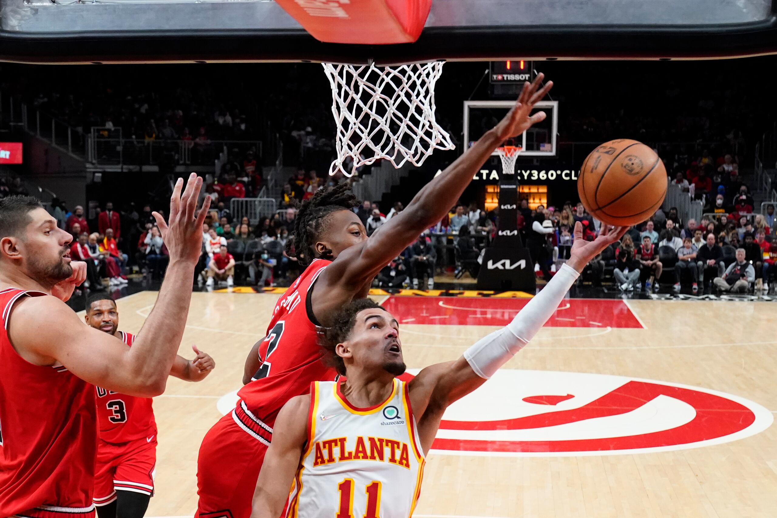 Trae Young, de los Hawks de Atlanta, busca colar un intento ante la defensa de Ayo Dosunmu, de los Bulls, quien le bloqueó el disparo.