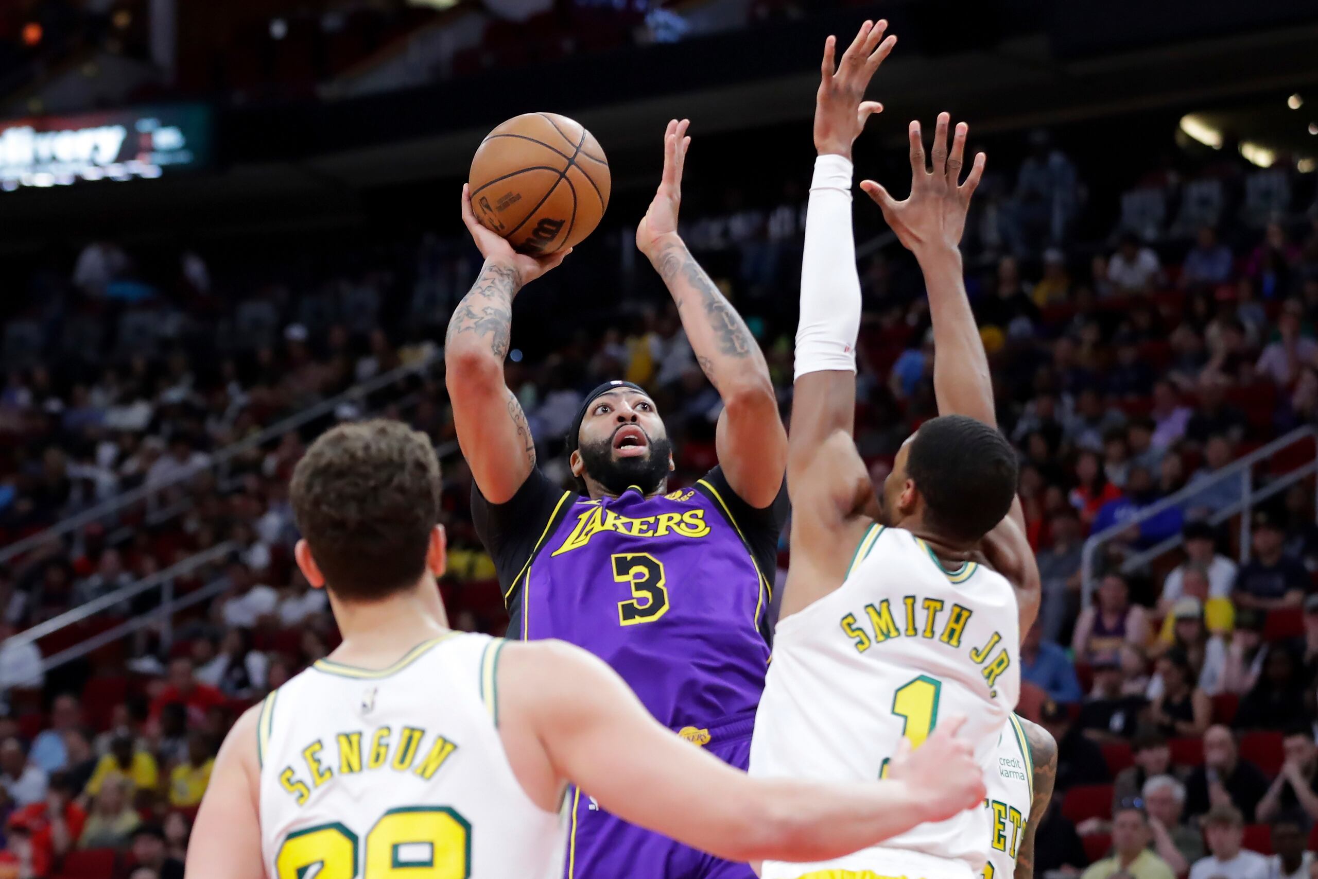 Anthony Davis, de los Lakers de Los Ángeles, dispara entre Alperen Sengun y Jabari Smith Jr., de los Rockets de Houston, el domingo 2 de abril de 2023 (AP Foto/Michael Wyke)