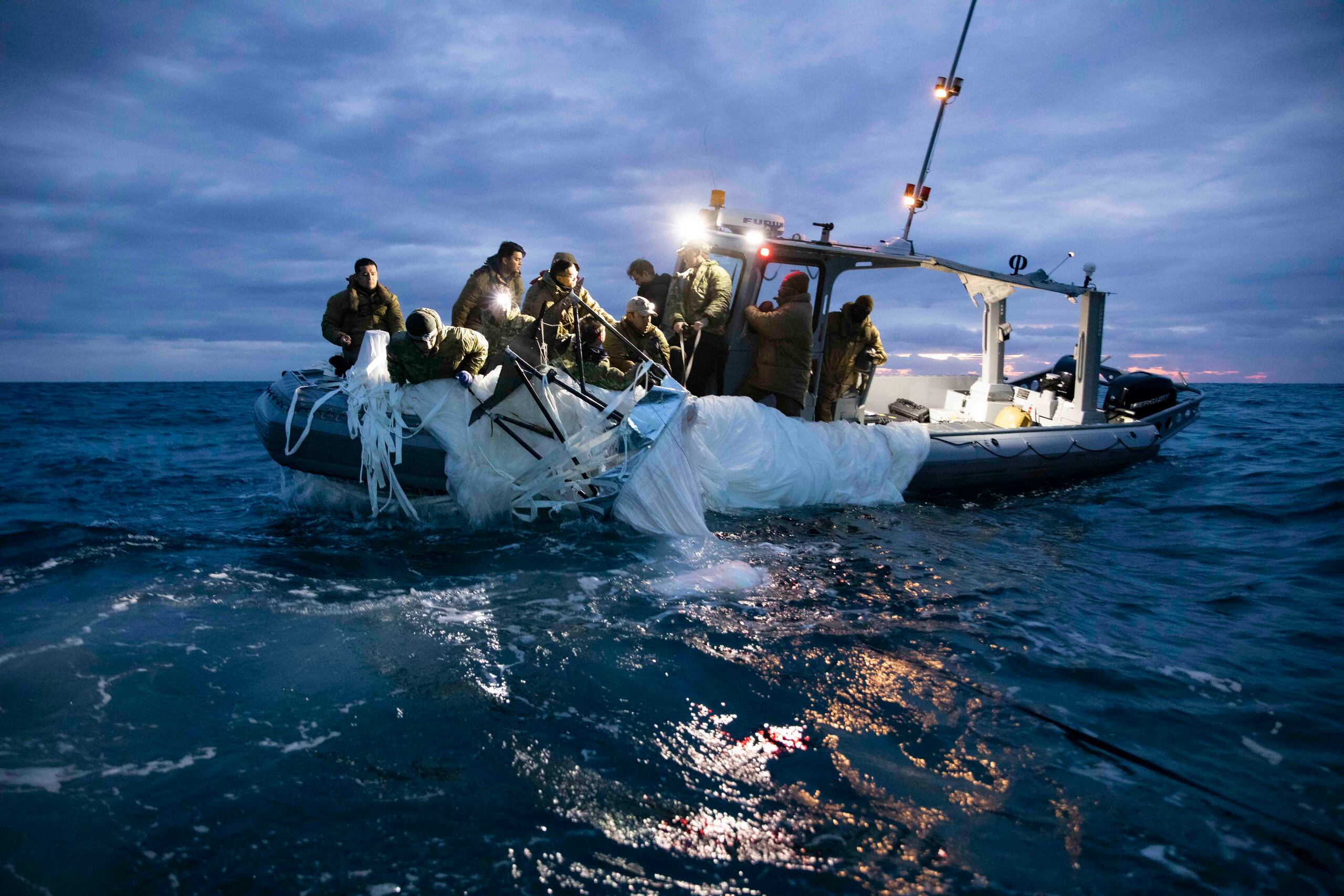 Fotografía cedida por la Armada de Estados Unidos donde aparecen unos marineros asignados al Grupo 2 de Eliminación de Artefactos Explosivos mientras recuperan el globo de vigilancia chino del mar, el 5 de febrero de 2023, frente a la costa de Myrtle Beach, Carolina del Sur. (EFE/Tyler Thompson U.S. Navy)