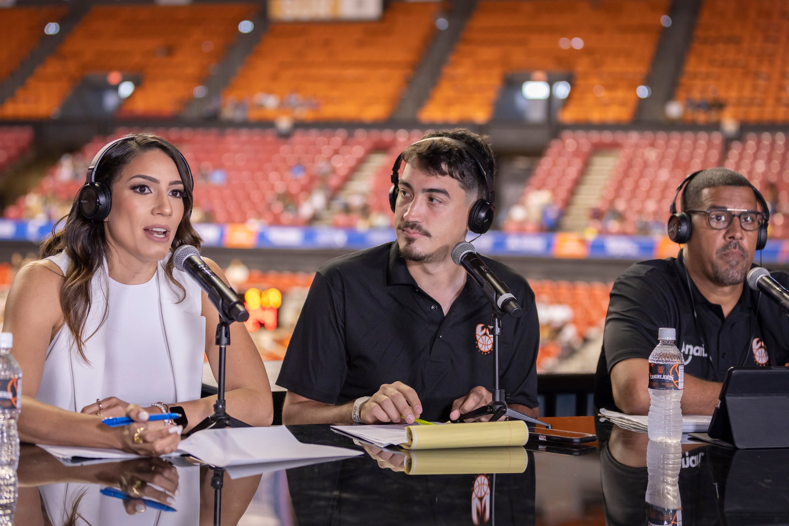 Xiomara Ríos toma su posición en la mesa de transmisión de los Cangrejeros junto al narrador, Javier Sabath (centro) el  exjugador, Alex Falcón.