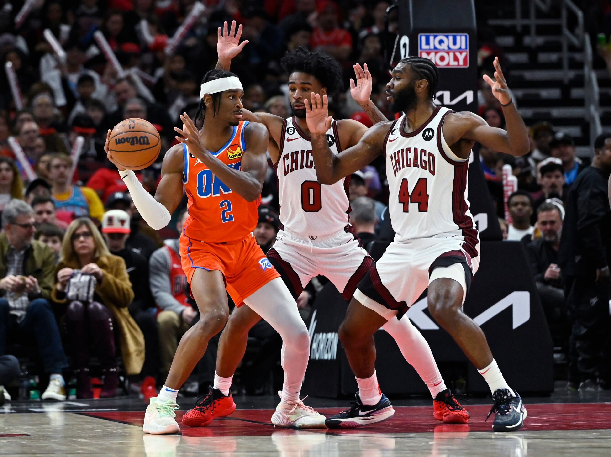 Shai Gilgeous-Alexander (2), del Thunder de Oklahoma City, pasa el balón lejos de Coby White (0) y  Patrick Williams (44), de los Bulls de Chicago, durante la segunda mitad del encuentro.