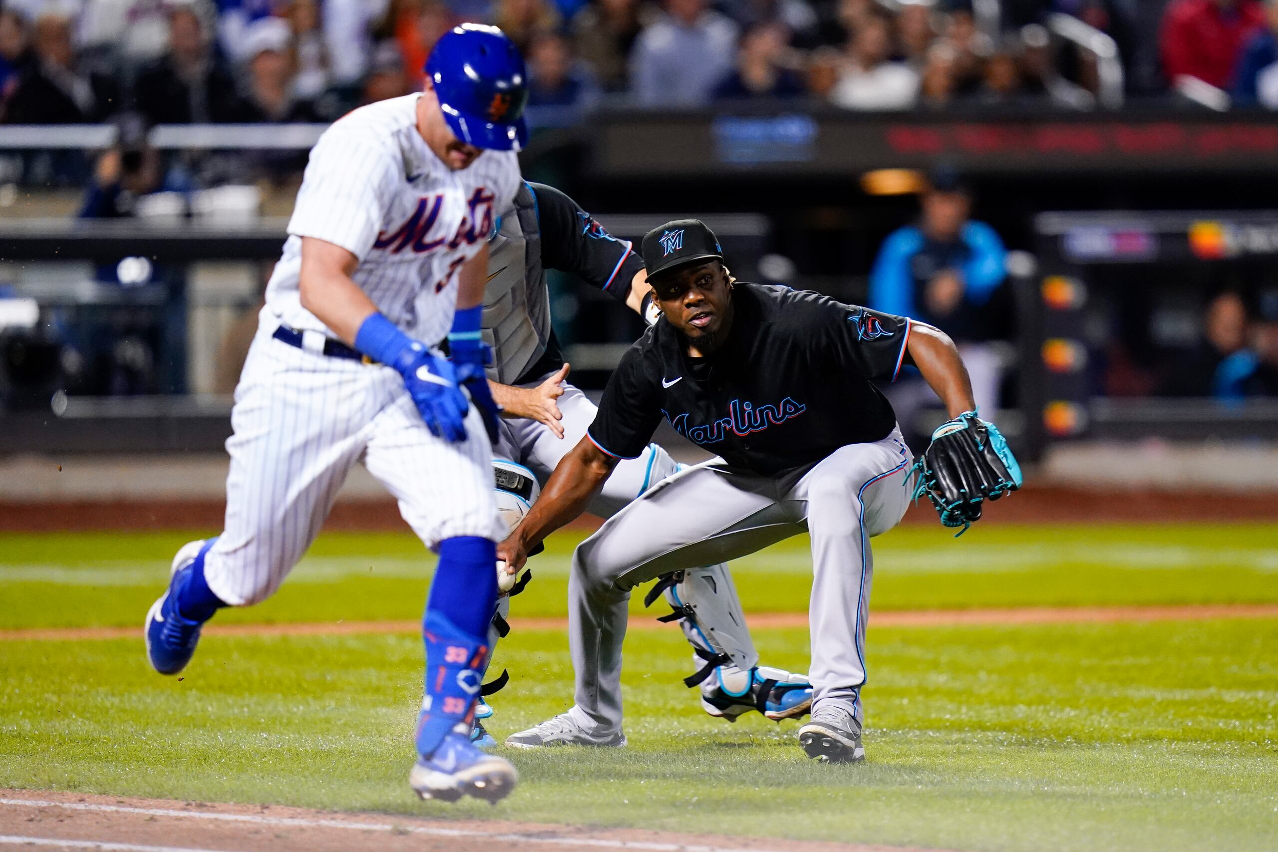 El relevista de los Marlins de Miami, Huáscar Brazobán, recoge la pelota para lanzar a la inicial y poner fuera al corredor de los Mets de Nueva York, James McCann.