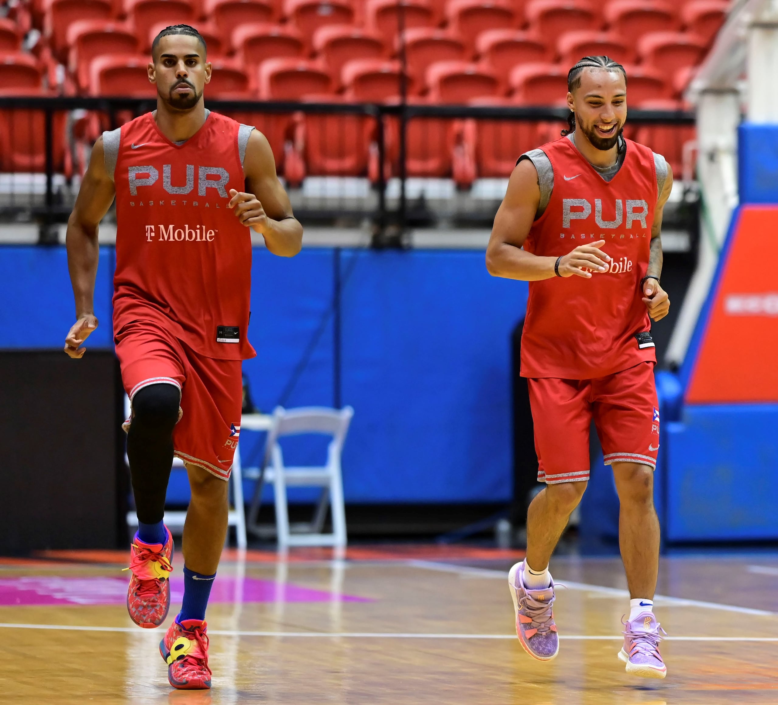 José Alvarado, a la derecha, deja escapar una sonrisa durante la práctica del jueves del equipo nacional de baloncesto mientras realiza calentamientos junto a Gian Clavell.