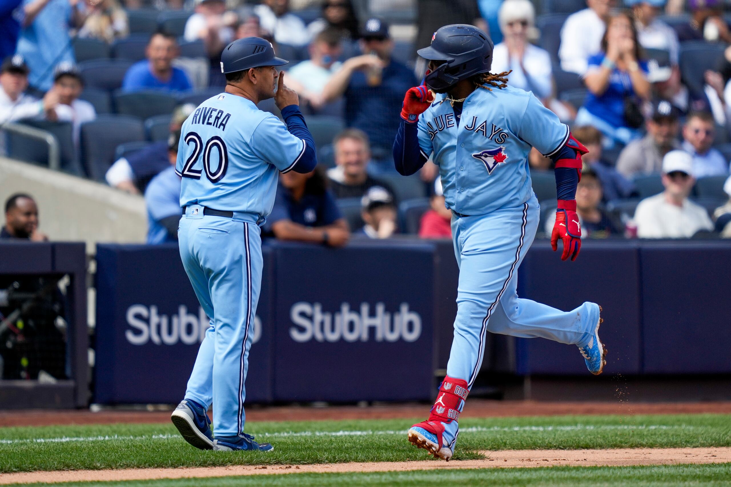 Vladimir Guerrero Jr. se coloca un dedo sobre su boca, al igual que el coach boricua Luis 'Papa' Rivera, tras un jonrón del primero.