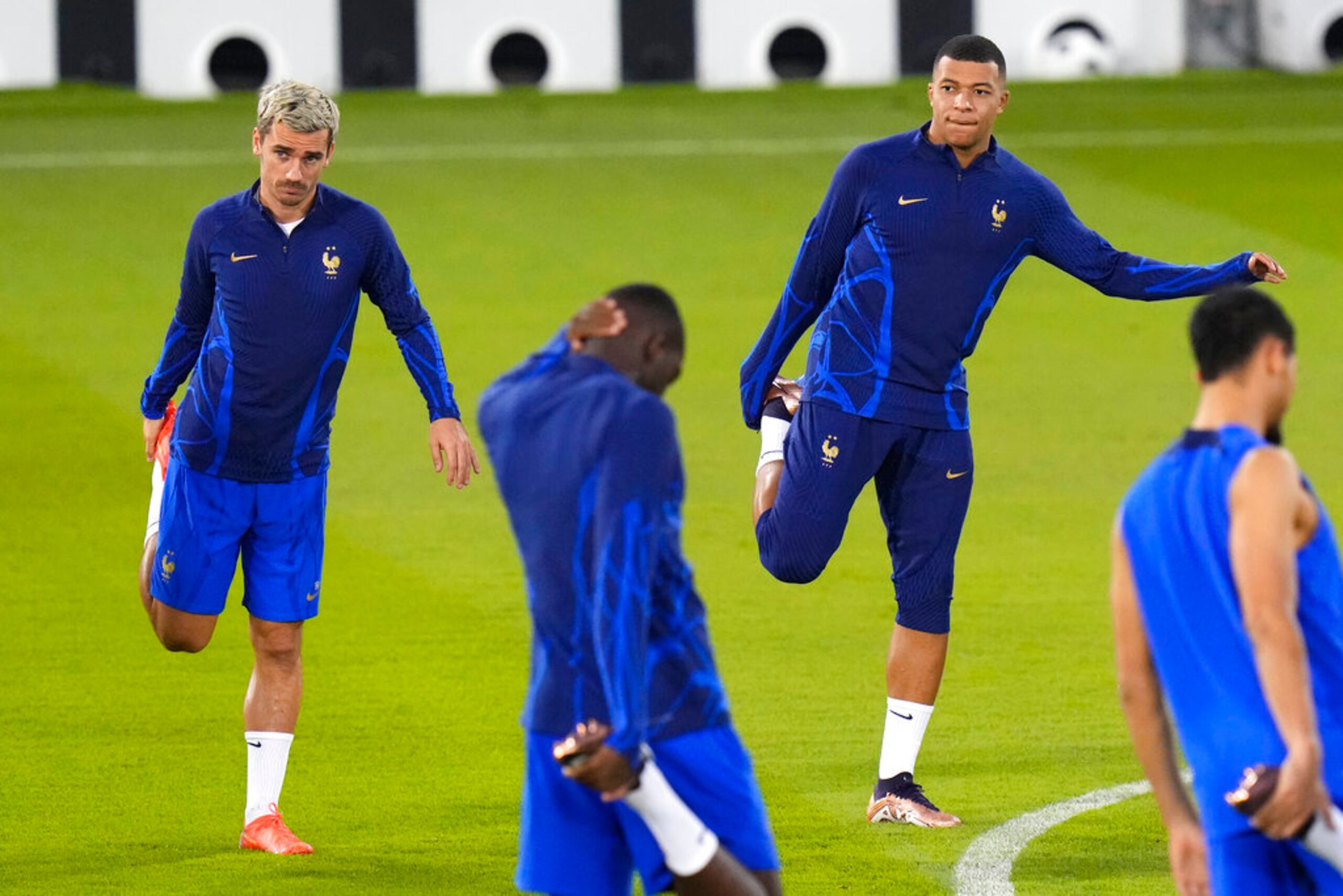 Kylian Mbappé (derecha) y Antoine Griezmann se estiran durante un entrenamiento.