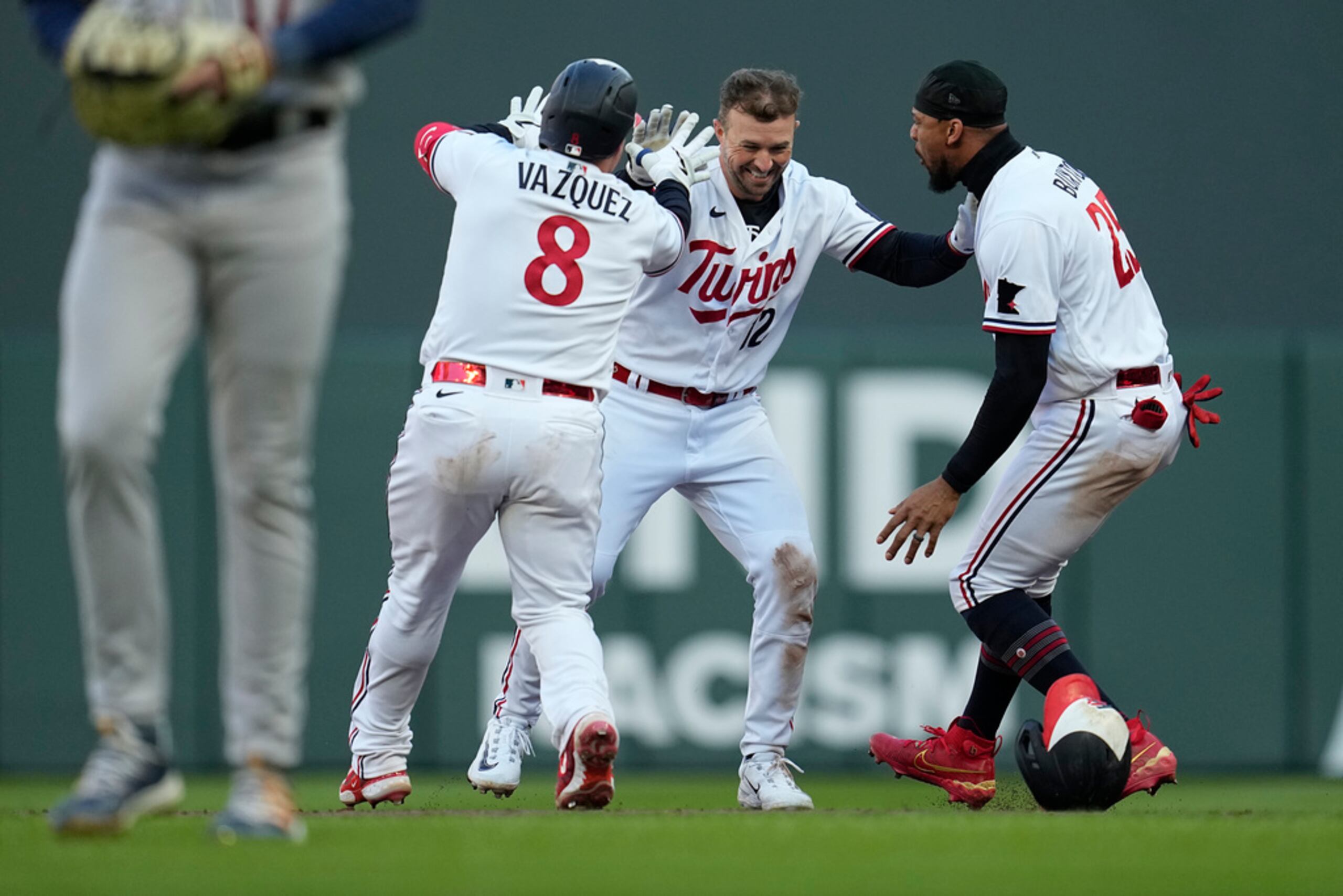 Kyle Farmer (al centro) celebra con  Christian Vázquez y Byron Buxton después de remolcar la carrera decisiva a favor de los Twins.