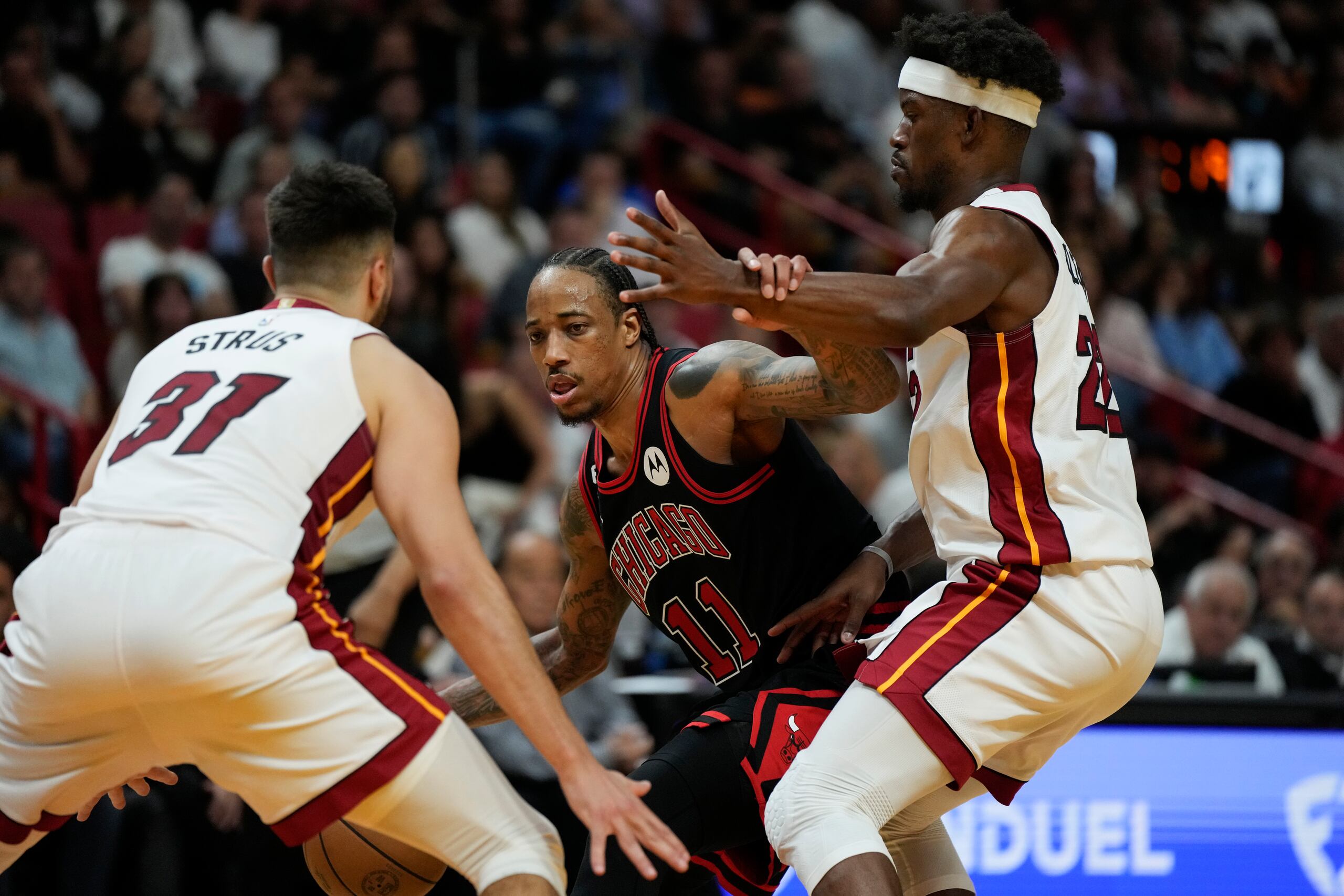 El delantero de los Bulls de Chicago, DeMar DeRozan, al centro, es presionado por Max Strus (31) y Jimmy Butler (derecha), del Heat de Miami durante el desafío del viernes.