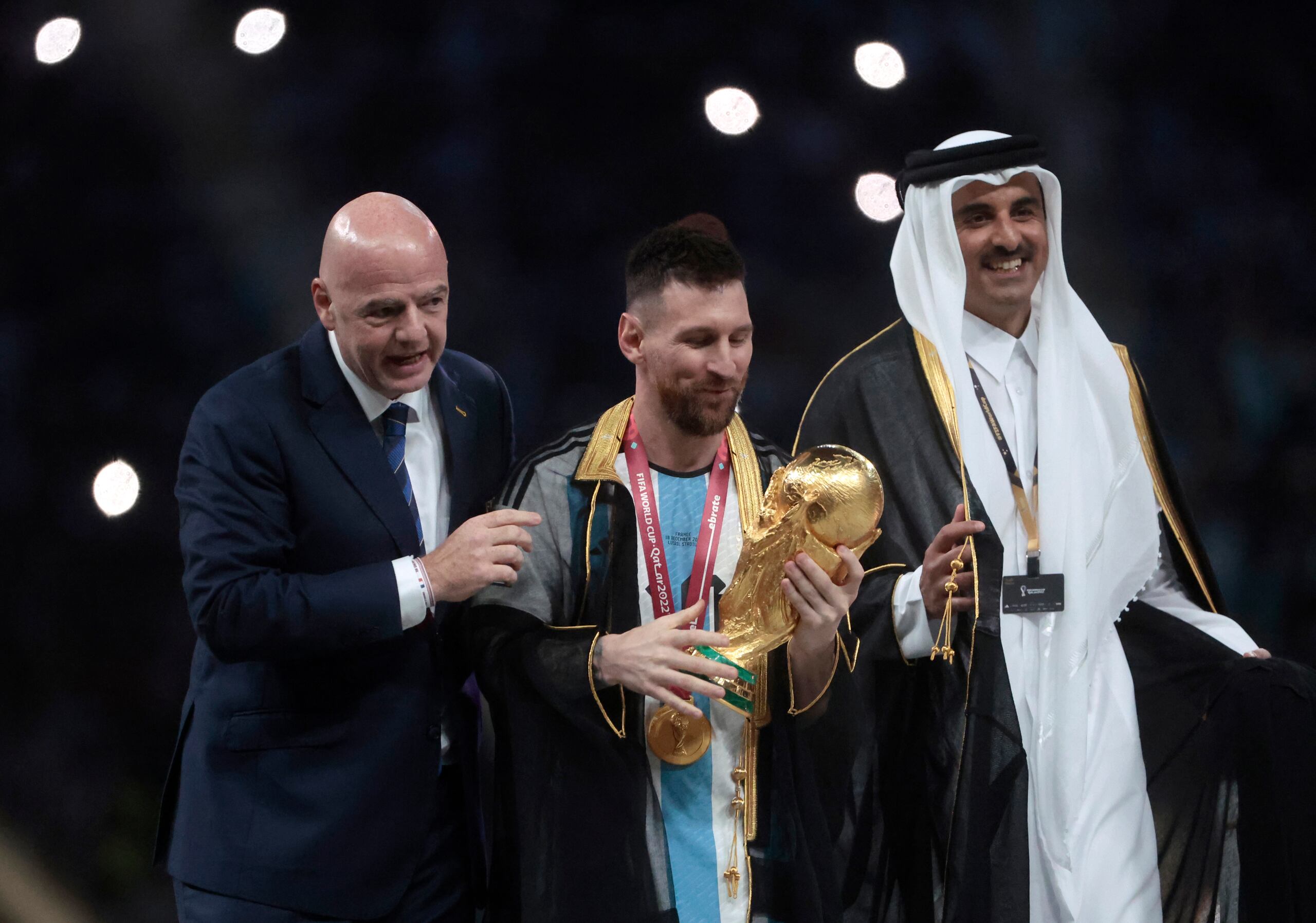 Lionel Messi posa con el trofeo de la Copa del Mundo junto a el presidente de la FIFA Giovanni Vincenzo (izquierda) y el Emir del Estado de Catar, Tamim bin Hamad Al Thani.