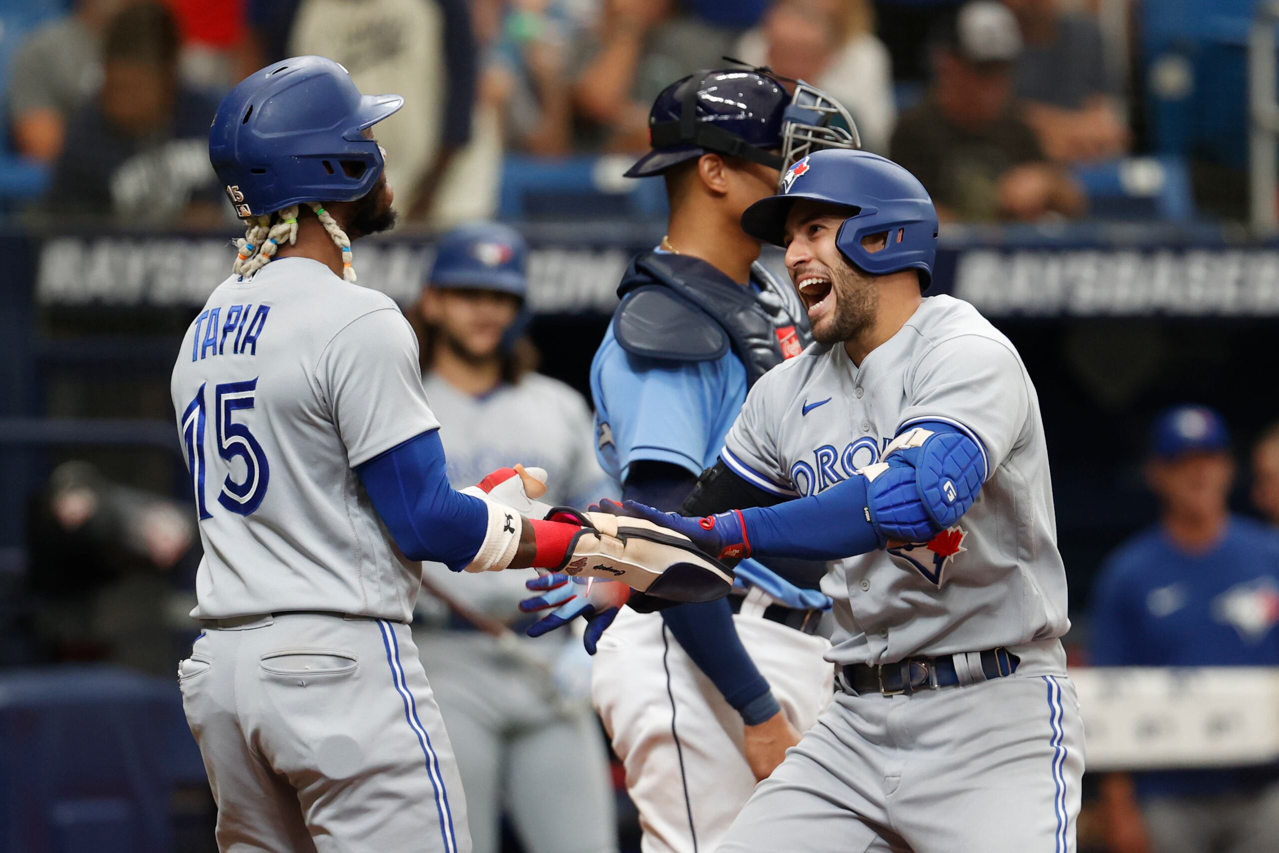 George Springer (derecha) de los Blue Jays de Toronto celebra con su compañero Ramiel Tapia tras conectar un jonrón ante los Rays de Tampa Bay.