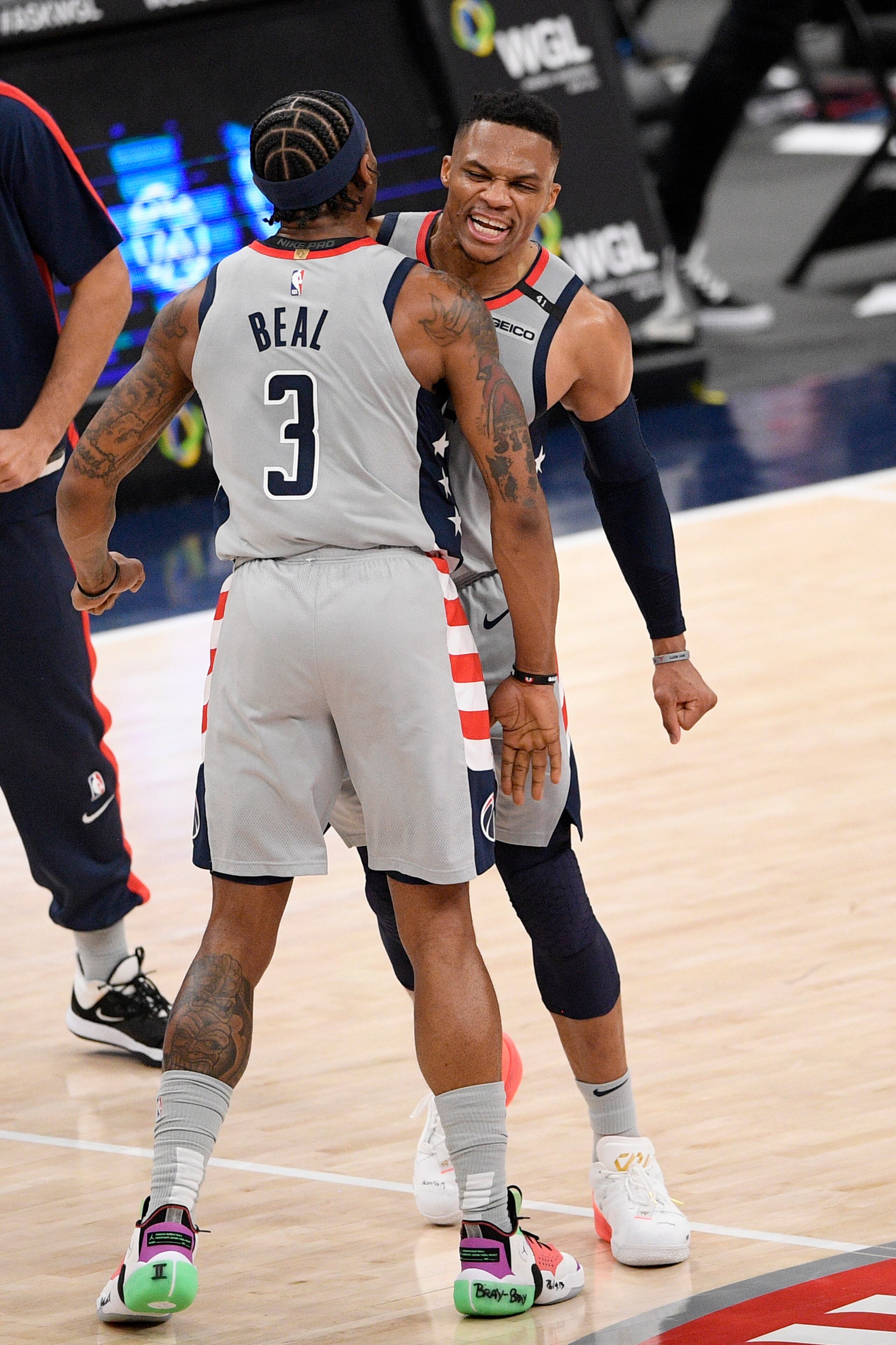 Bradley Beal, de los Wizards, celebra con su compañero Russell Westbrook luego de que Beal colara su importante triple en el encuentro de anoche ante los Nets.