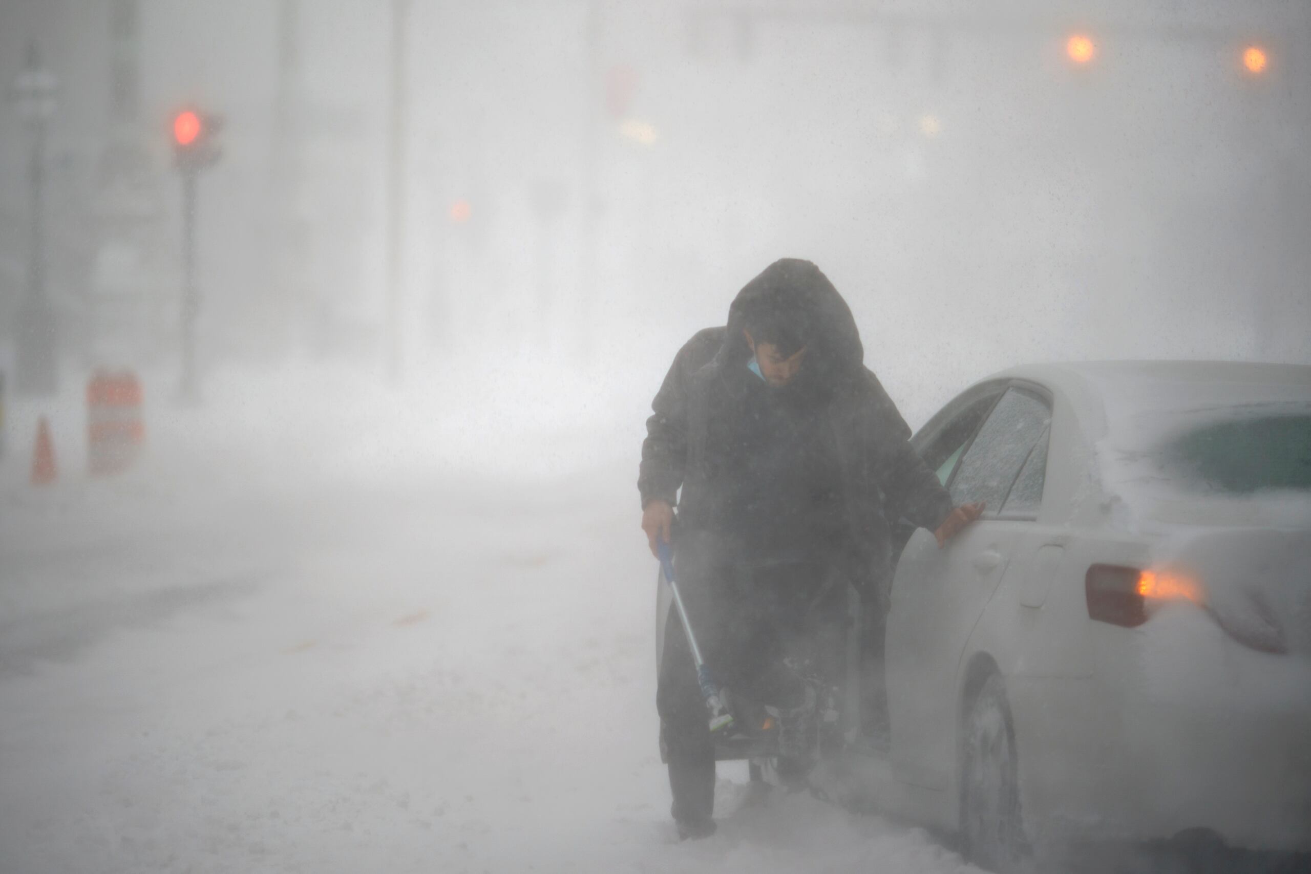 Un conductor varado intenta sacar la viene de las gomas de su auto en medio de la nevada en Providence, Rhode Island.