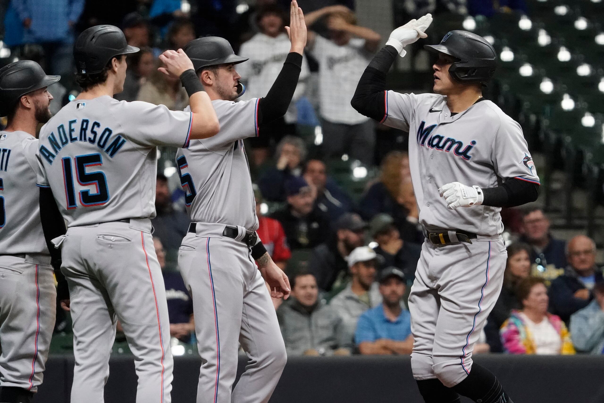 Avisaíl García, de los Marlins de Miami, a la derecha, es recibido por sus compañeros en el plato luego de disparar un 'grand slam' el jueves en Milwaukee.