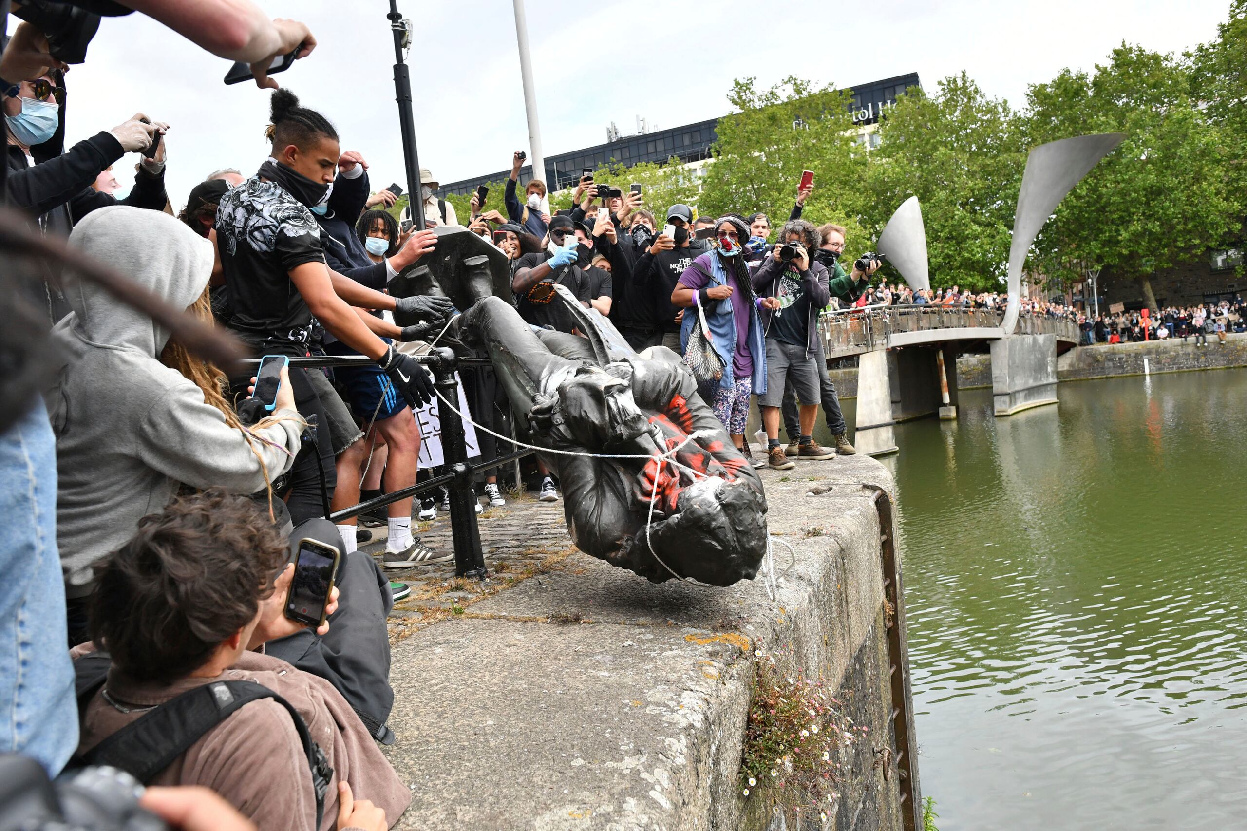 Manifestantes arrojan al agua la estatua del comerciante de esclavos Edward Colston en Bristol, Inglaterra