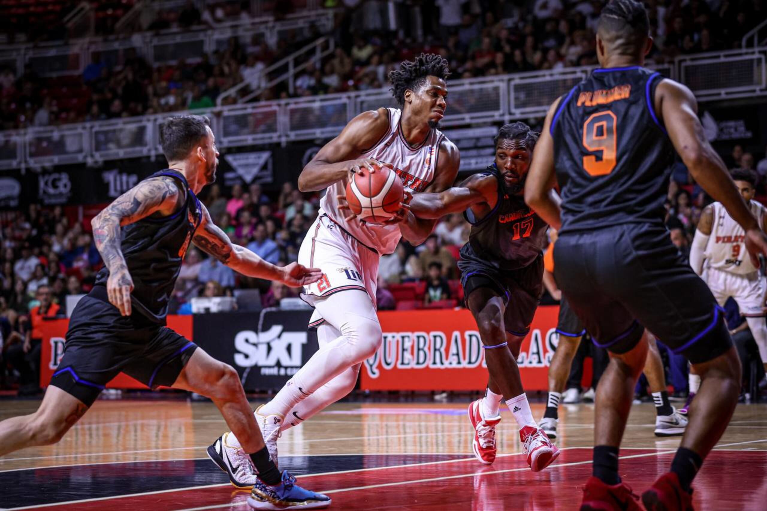 Hassan Whiteside intenta penetrar mientras un jugador de los Cangrejeros busca robarle el balón.