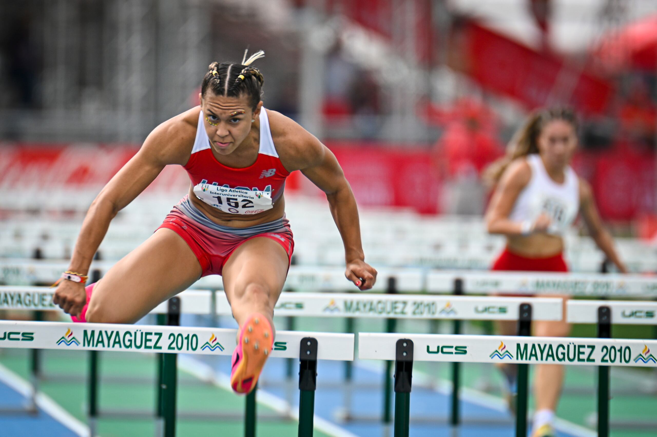 Jomarie Carmona, de la Universidad Ana G. Méndez, supera un obstáculo durante la competencia de los 100 metros con vallas.