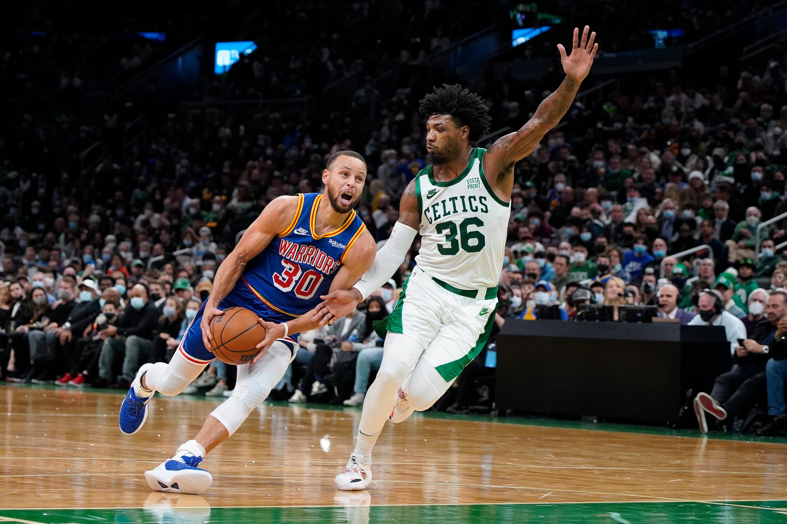 Stephen Curry se dirige al canasto contra el escolta de los Celtics de Boston Marcus Smart durante la segunda mitad del juego del viernes, 17 de diciembre, en Boston.