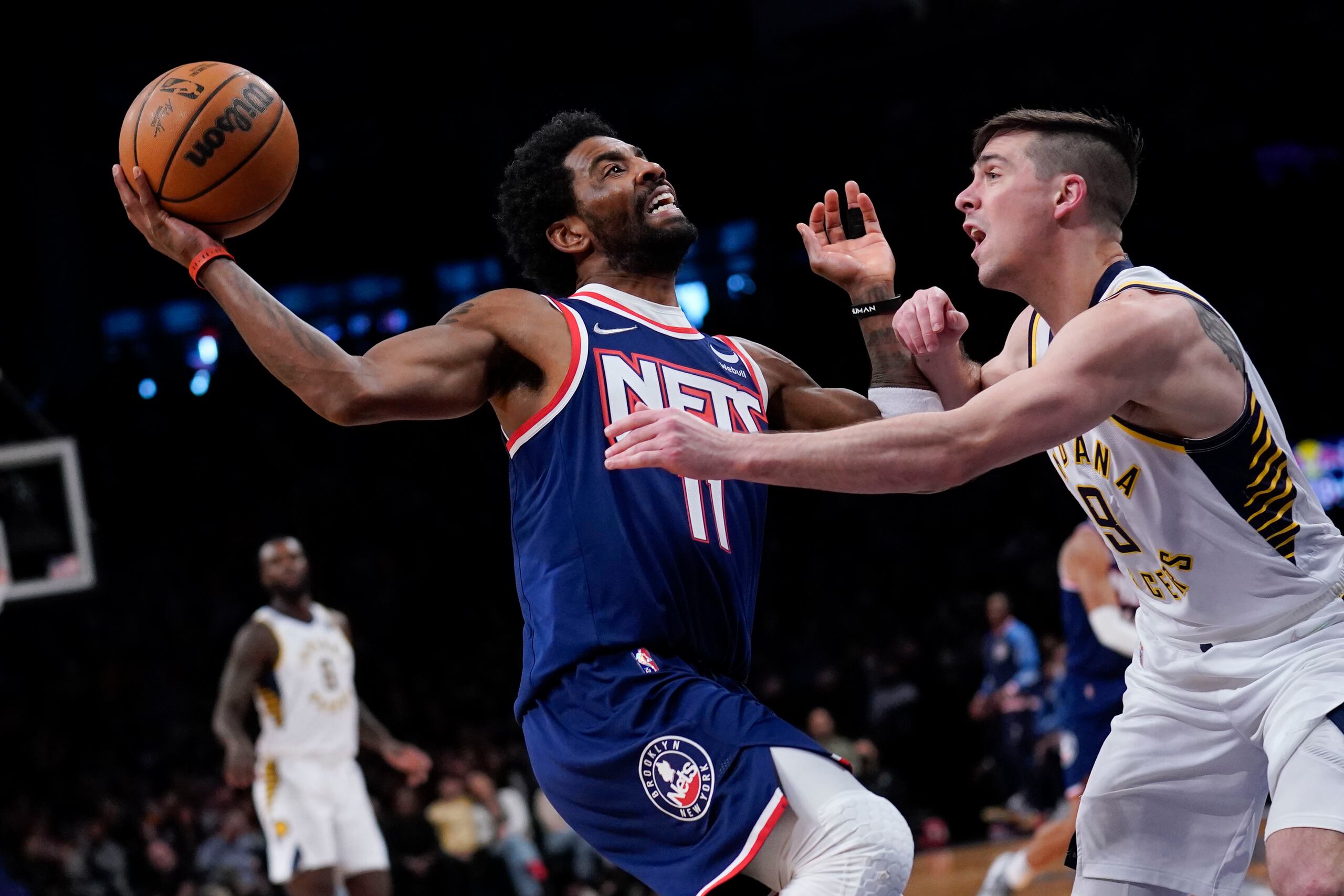 Kyrie Irving de los Nets de Brooklyn avanza hacia la canasta mientras lo defiende T.J. McConnell de los Pacers de Indiana en el encuentro del domingo 10 de abril del 2022. (AP Foto/Seth Wenig)