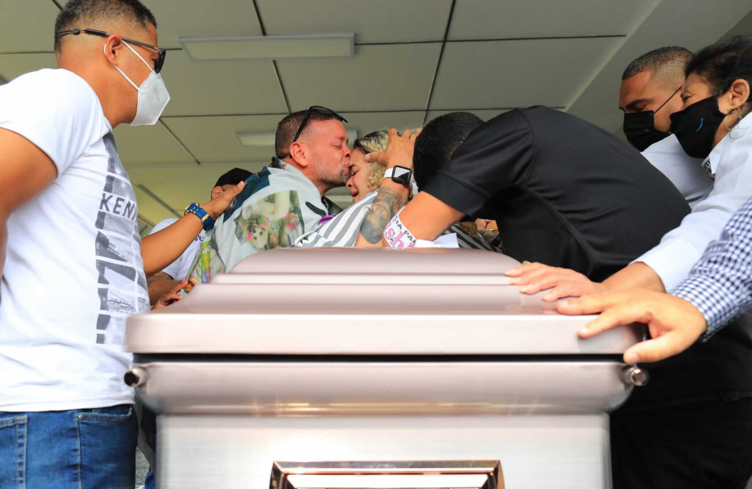 El padre de Keishla Rodríguez, José Rodríguez, abraza y besa a la hermana de Keishla, Bereliz Rodríguez, en momentos en que sacan de la funeraria Ehret el féretro de la joven.