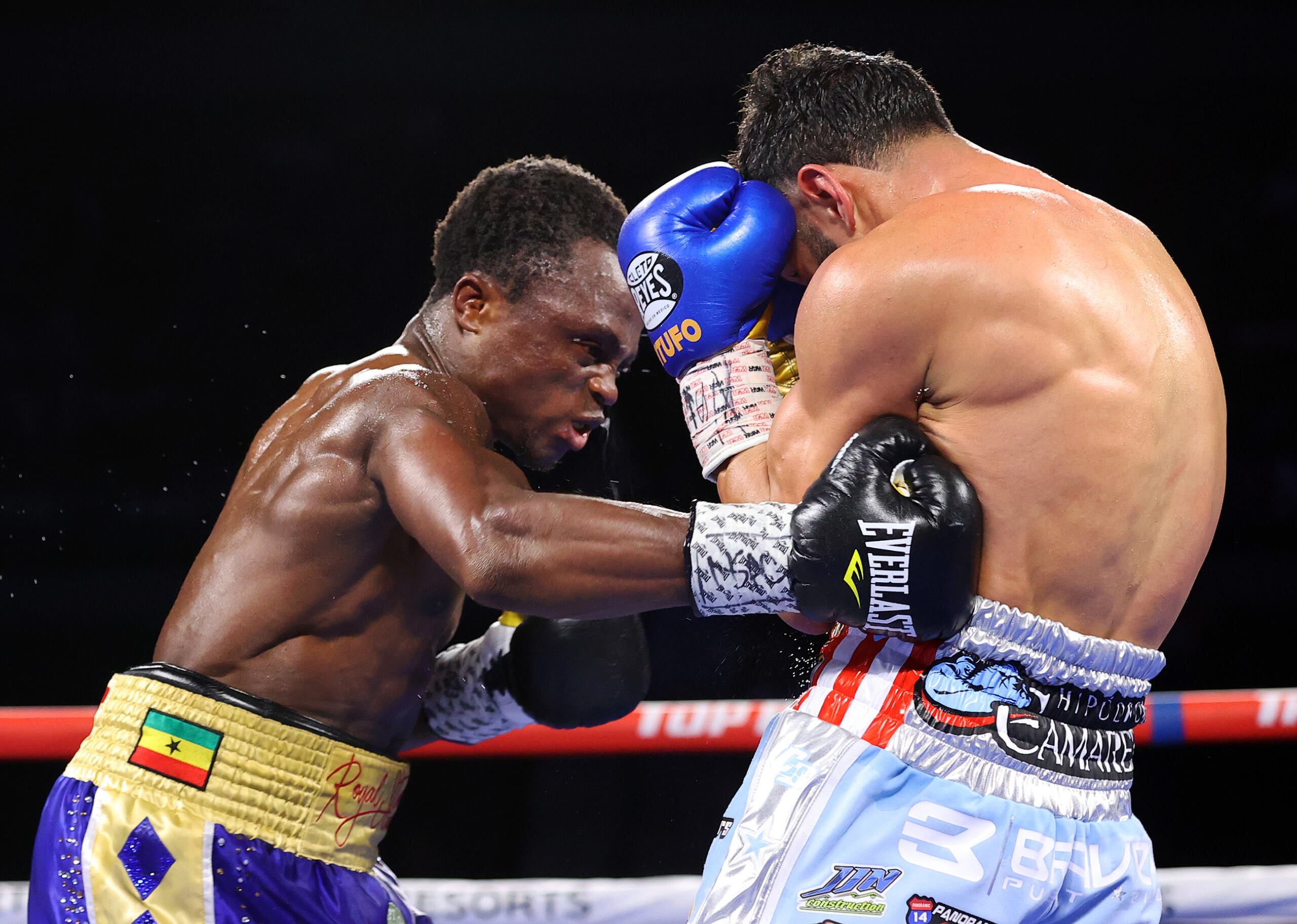 Isaac Dogboe conecta un gancho al cuerpo de Christopher 'Pitufo' Díaz durante su combate del sábado en Las Vegas. Dogboe salió con un apretado triunfo por decisión mayoritaria sobre el puertorriqueño.